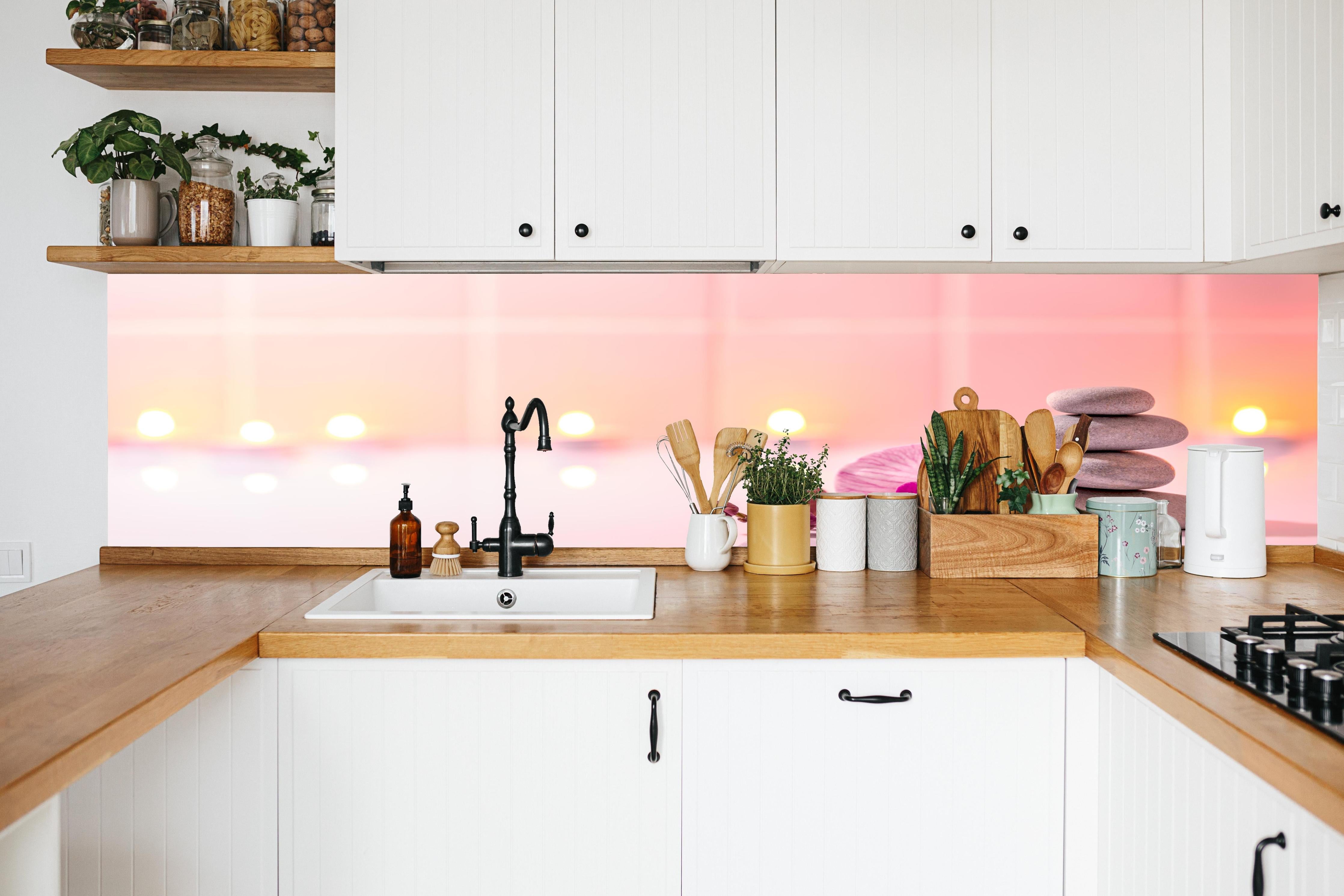 Küche - Rosa Orchidee mit Zen-Steinen in weißer Küche hinter Gewürzen und Kochlöffeln aus Holz