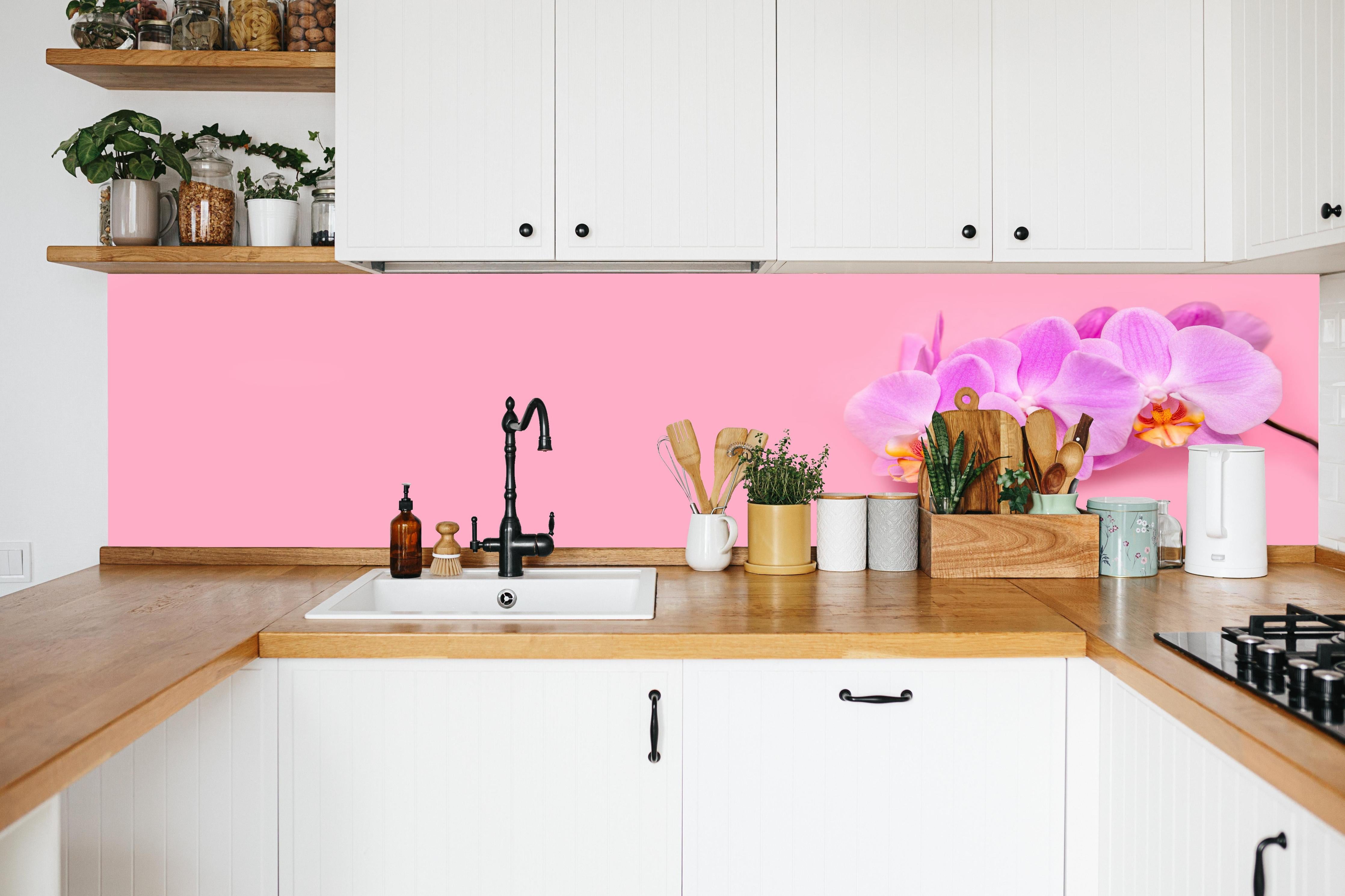 Küche - Rosa Orchideen auf Pink in weißer Küche hinter Gewürzen und Kochlöffeln aus Holz