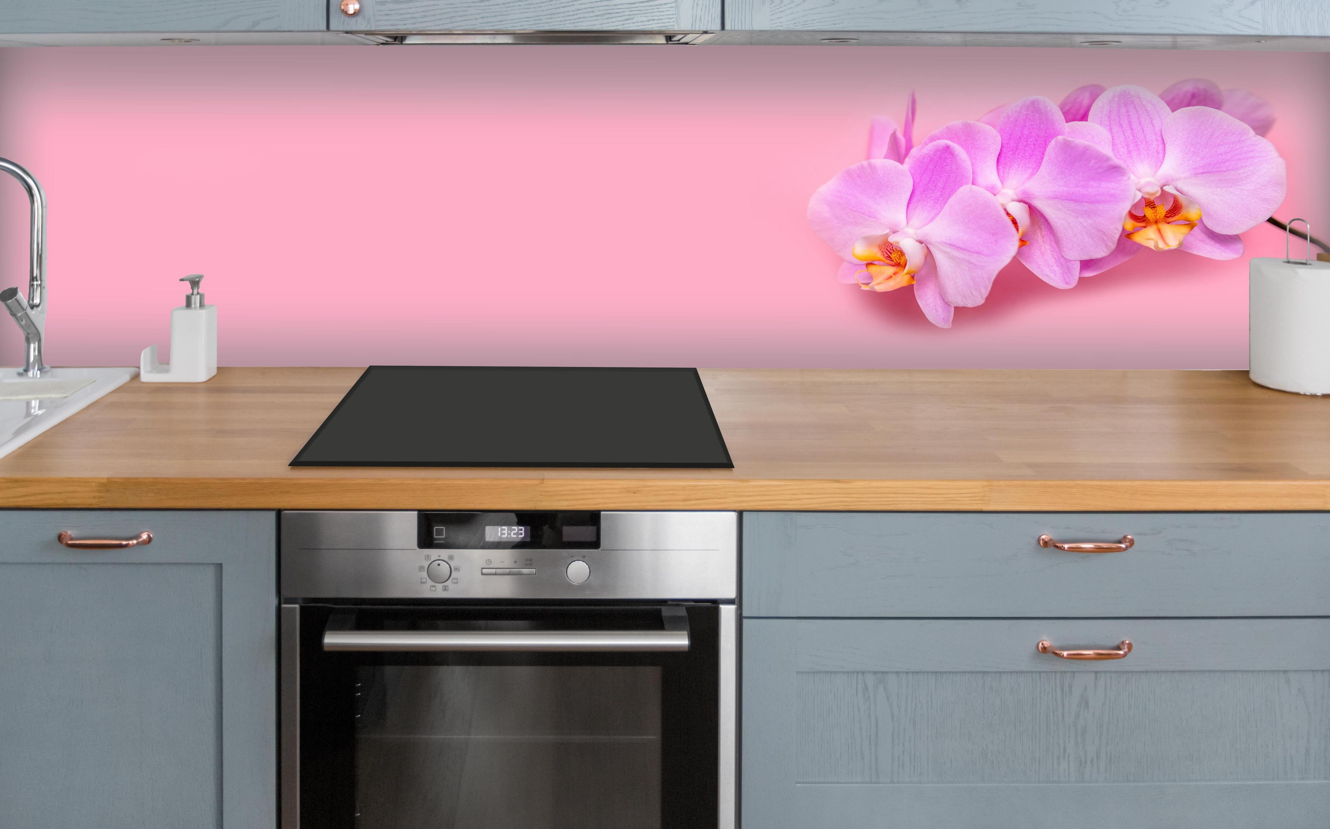 Küche - Rosa Orchideen auf Pink über polierter Holzarbeitsplatte mit Cerankochfeld