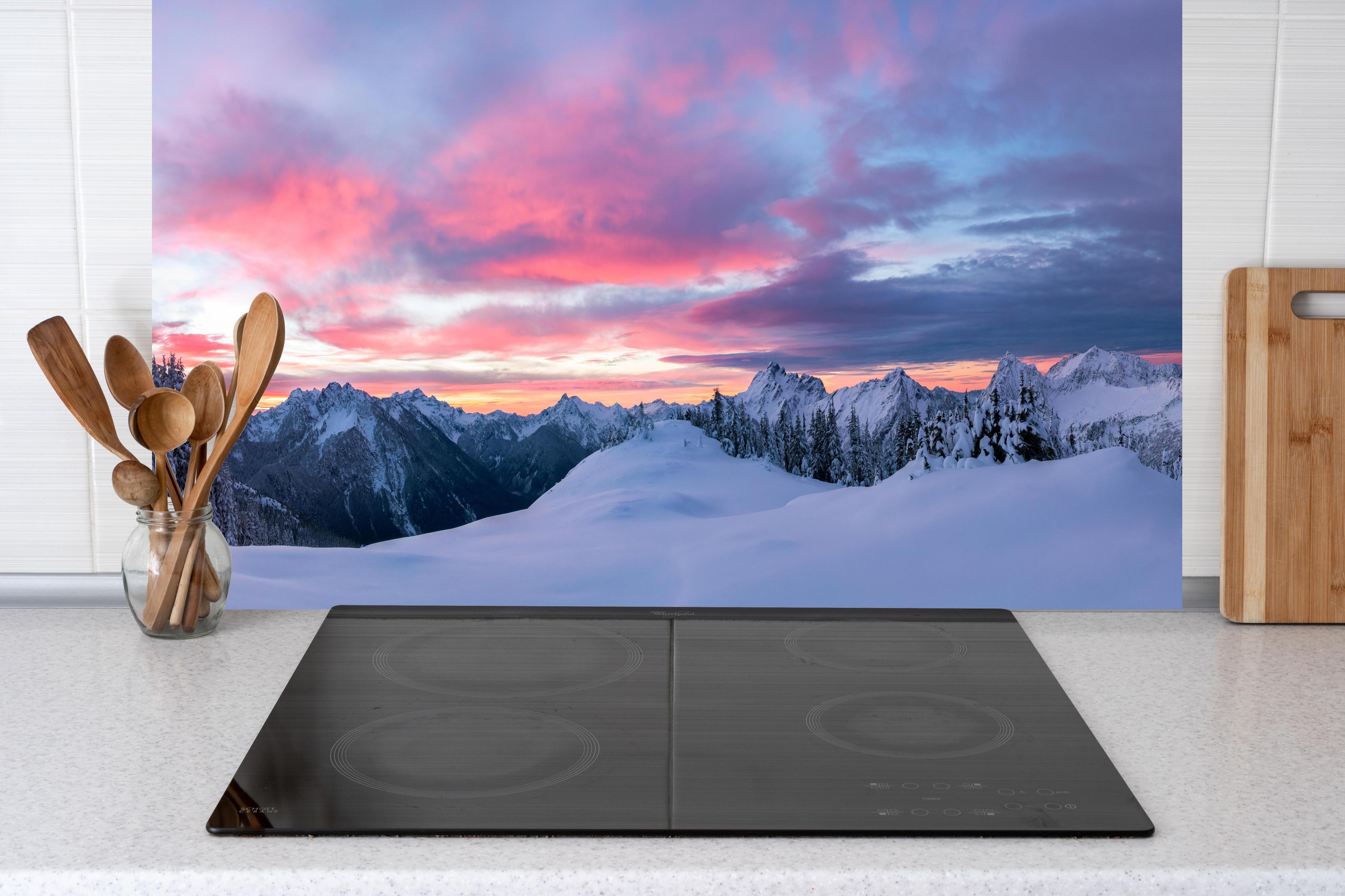 Küche - Rosa Sonnenuntergang Bergpanorama hinter Cerankochfeld und Holz-Kochutensilien