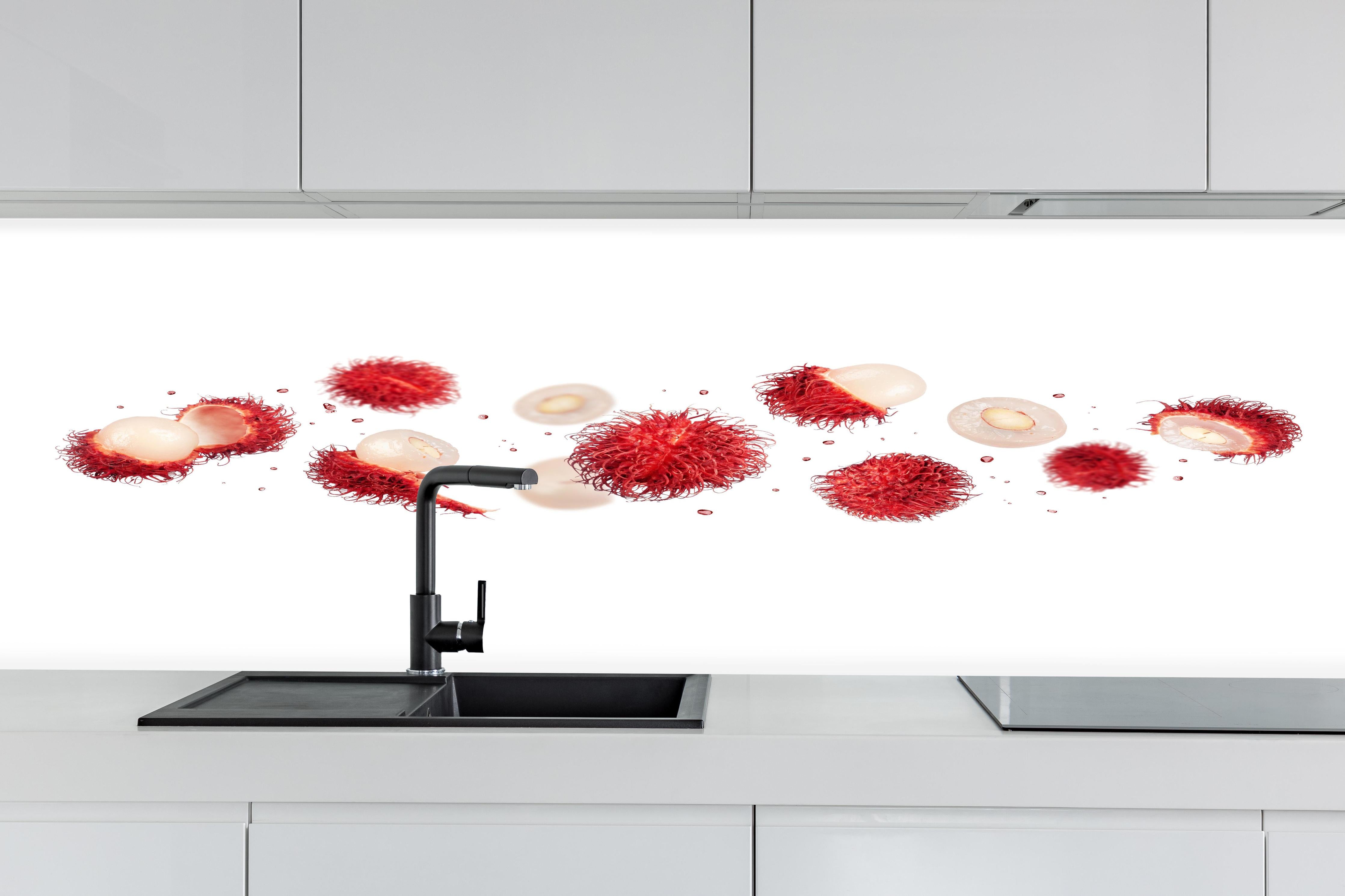 Küche - Rote Rambutan Früchte hinter weißen Hochglanz-Küchenregalen und schwarzem Wasserhahn