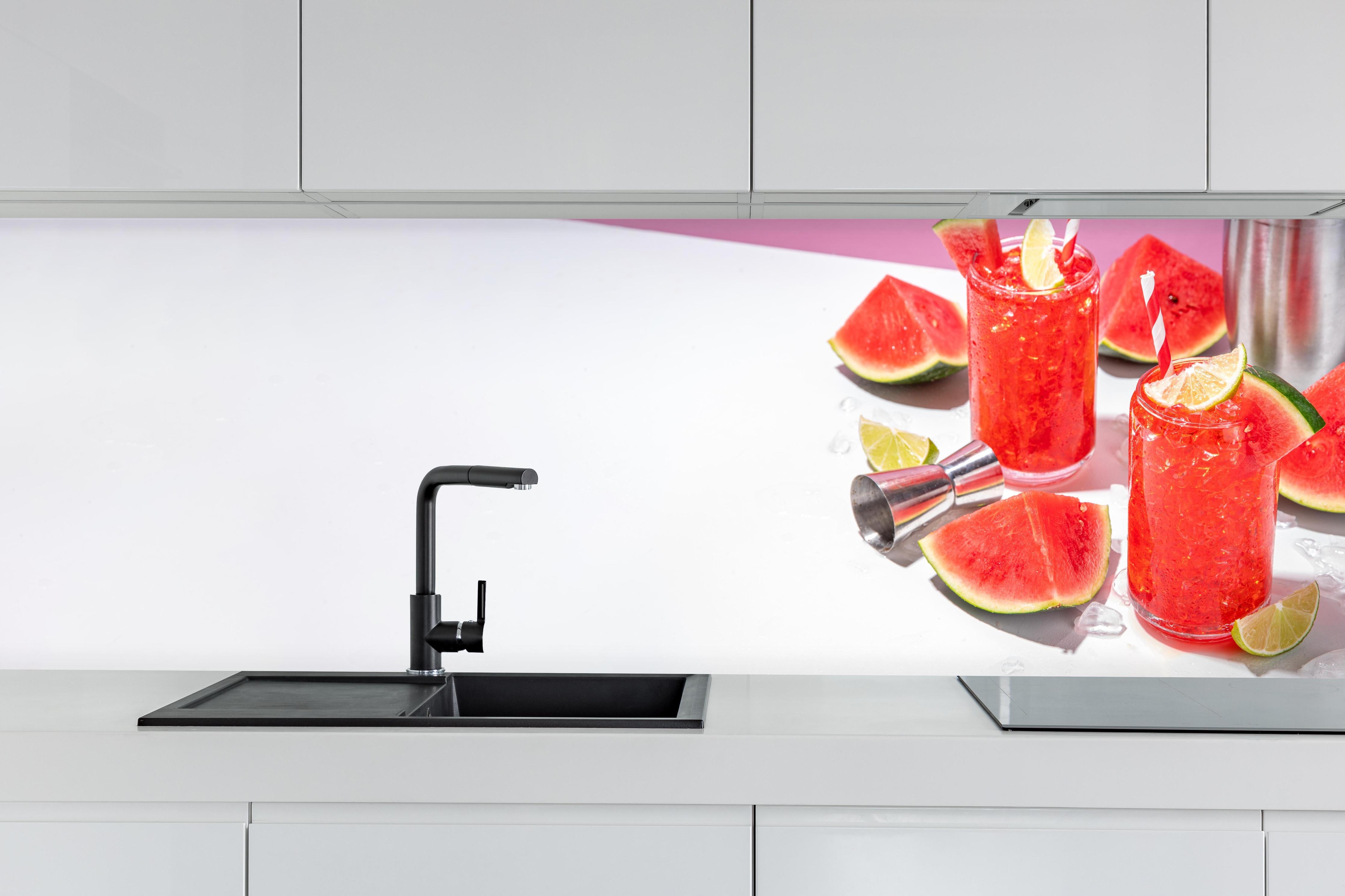 Küche - Roter Wassermelonen-Cocktail mit Limette hinter weißen Hochglanz-Küchenregalen und schwarzem Wasserhahn