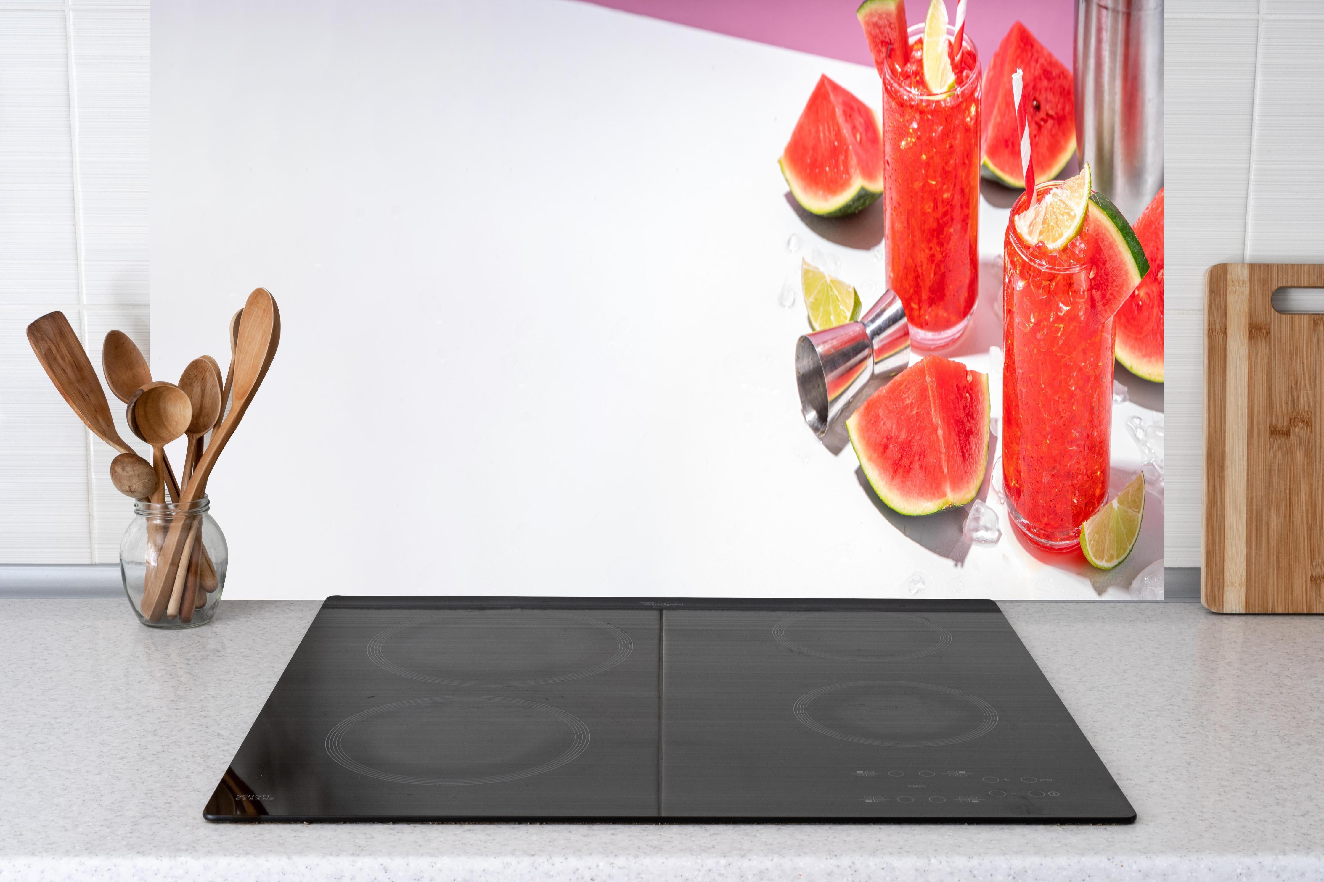 Küche - Roter Wassermelonen-Cocktail mit Limette hinter Cerankochfeld und Holz-Kochutensilien