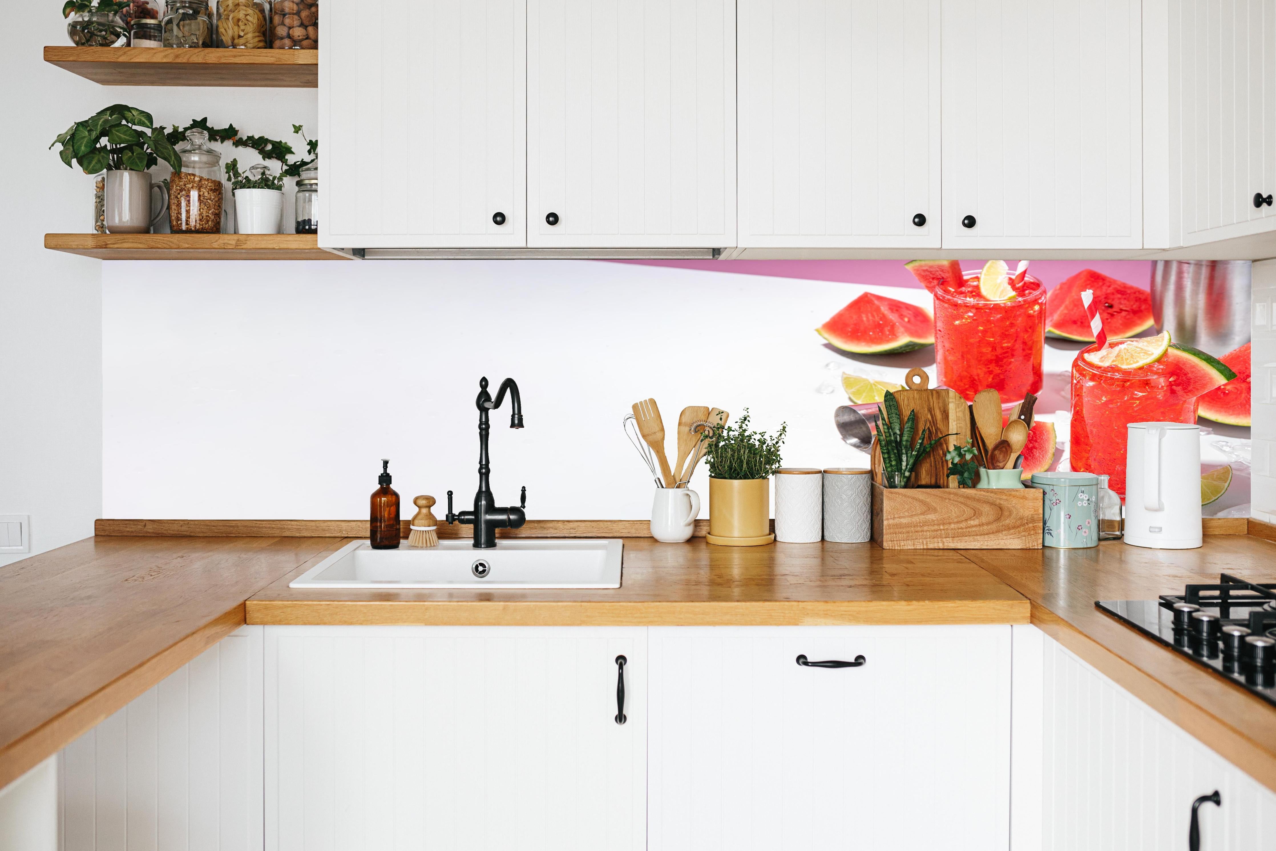 Küche - Roter Wassermelonen-Cocktail mit Limette in weißer Küche hinter Gewürzen und Kochlöffeln aus Holz