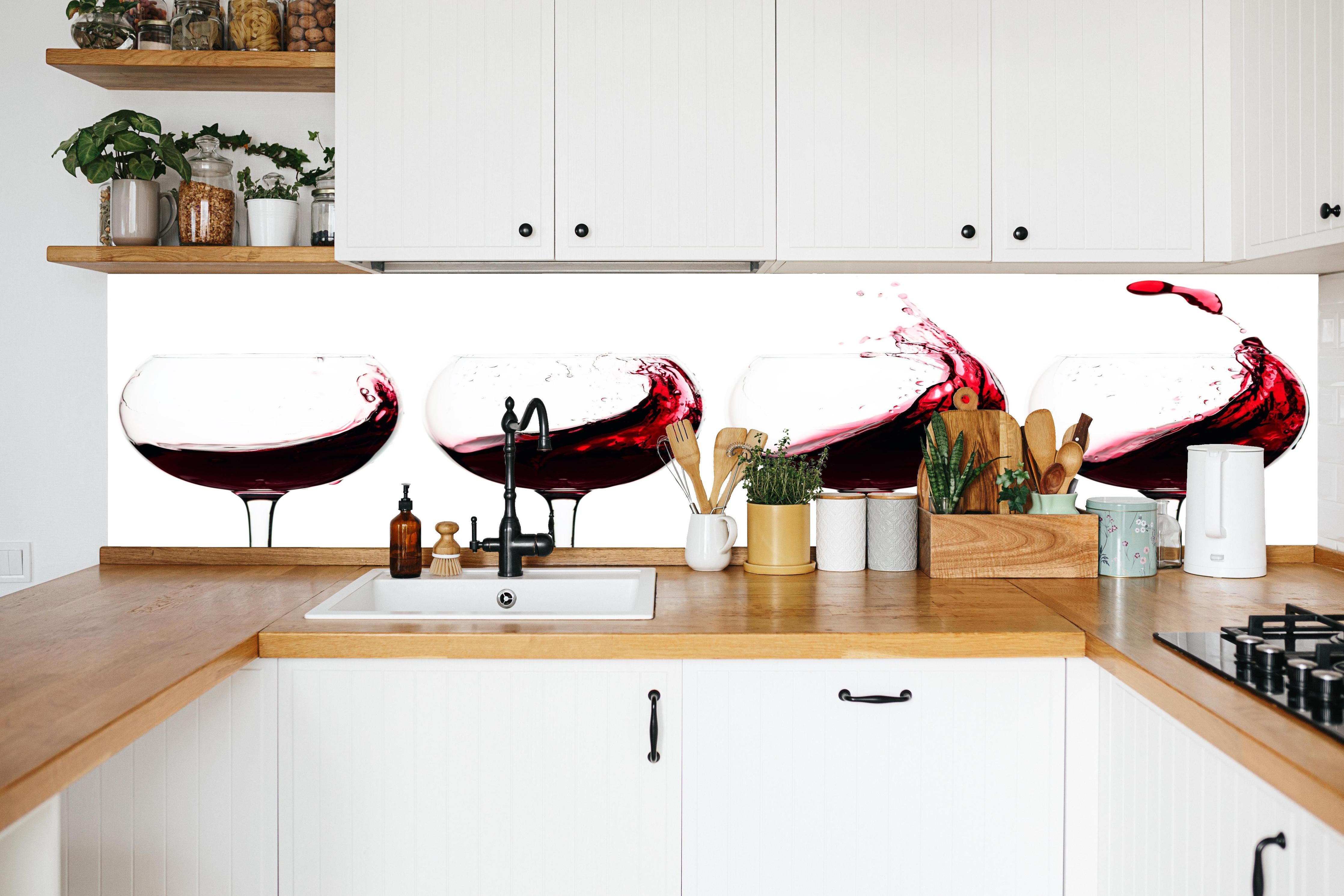 Küche - Rotwein-Splash in Weingläsern in weißer Küche hinter Gewürzen und Kochlöffeln aus Holz
