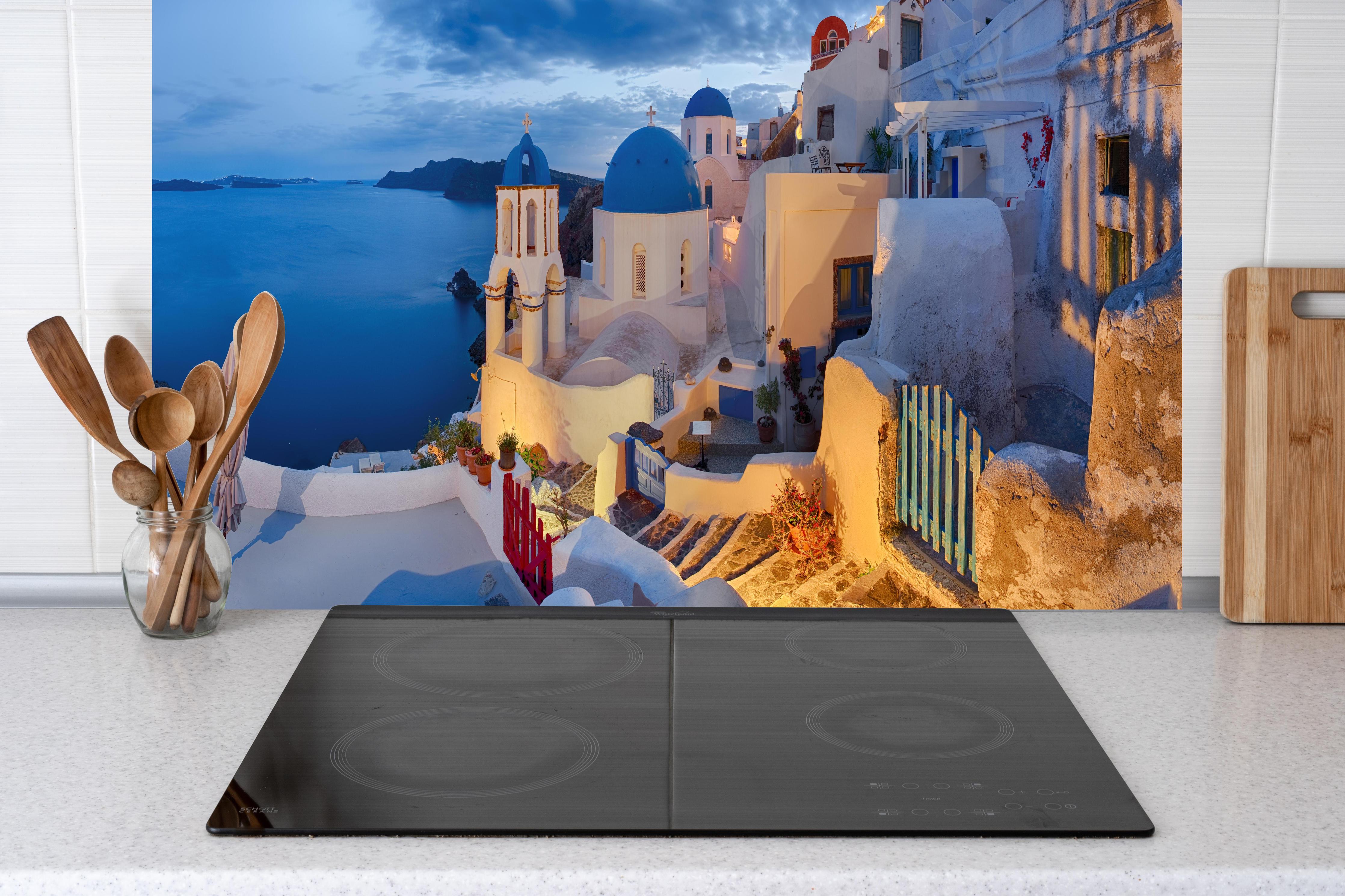 Küche - Santorini Skyline in Blau und Weiß hinter Cerankochfeld und Holz-Kochutensilien