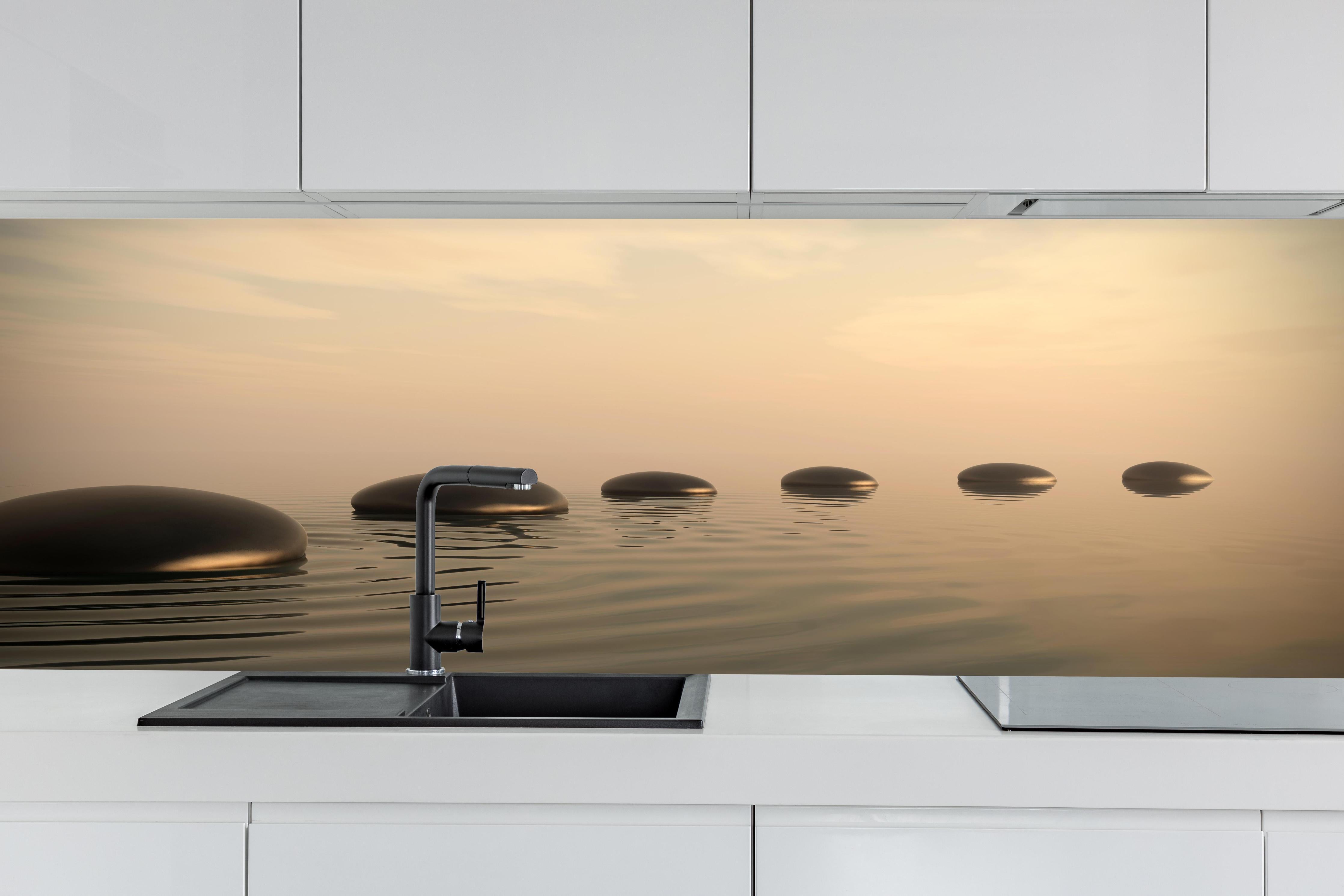 Küche - Schwarze Zen-Steine auf ruhigem Beige hinter weißen Hochglanz-Küchenregalen und schwarzem Wasserhahn
