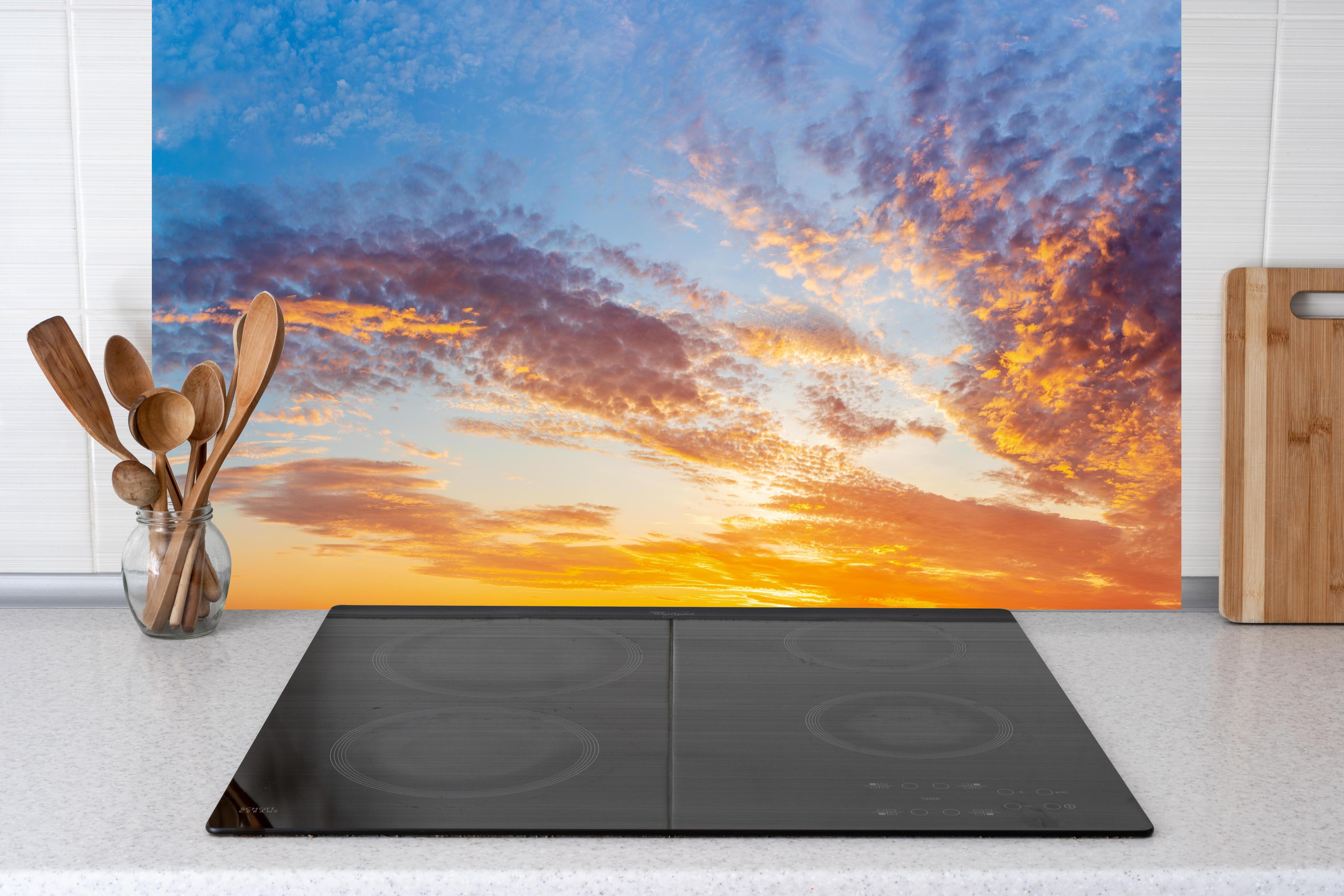 Küche - Sonnenuntergang Panorama Blau-Orange hinter Cerankochfeld und Holz-Kochutensilien