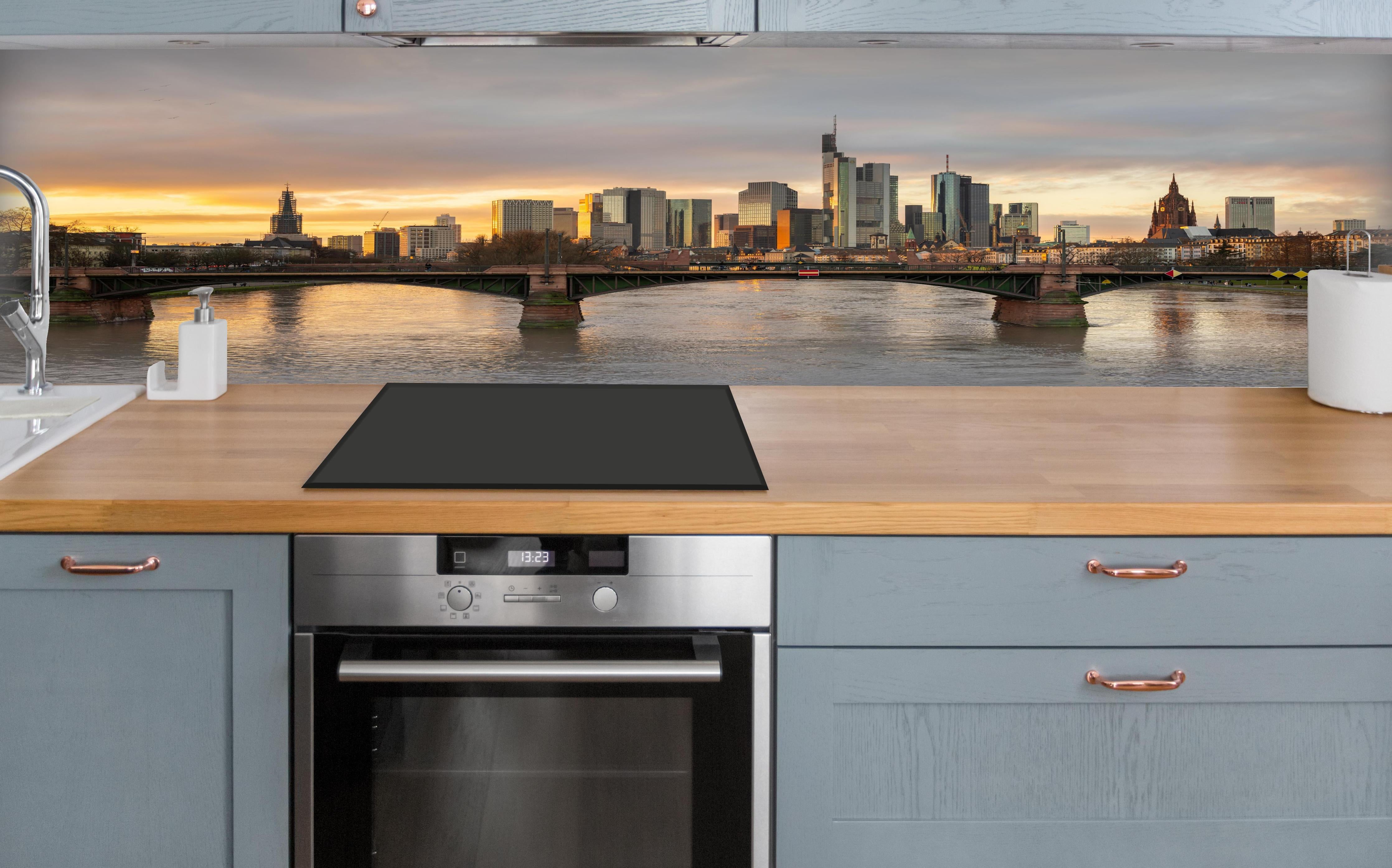 Küche - Stadt-Skyline im Abendlicht über polierter Holzarbeitsplatte mit Cerankochfeld