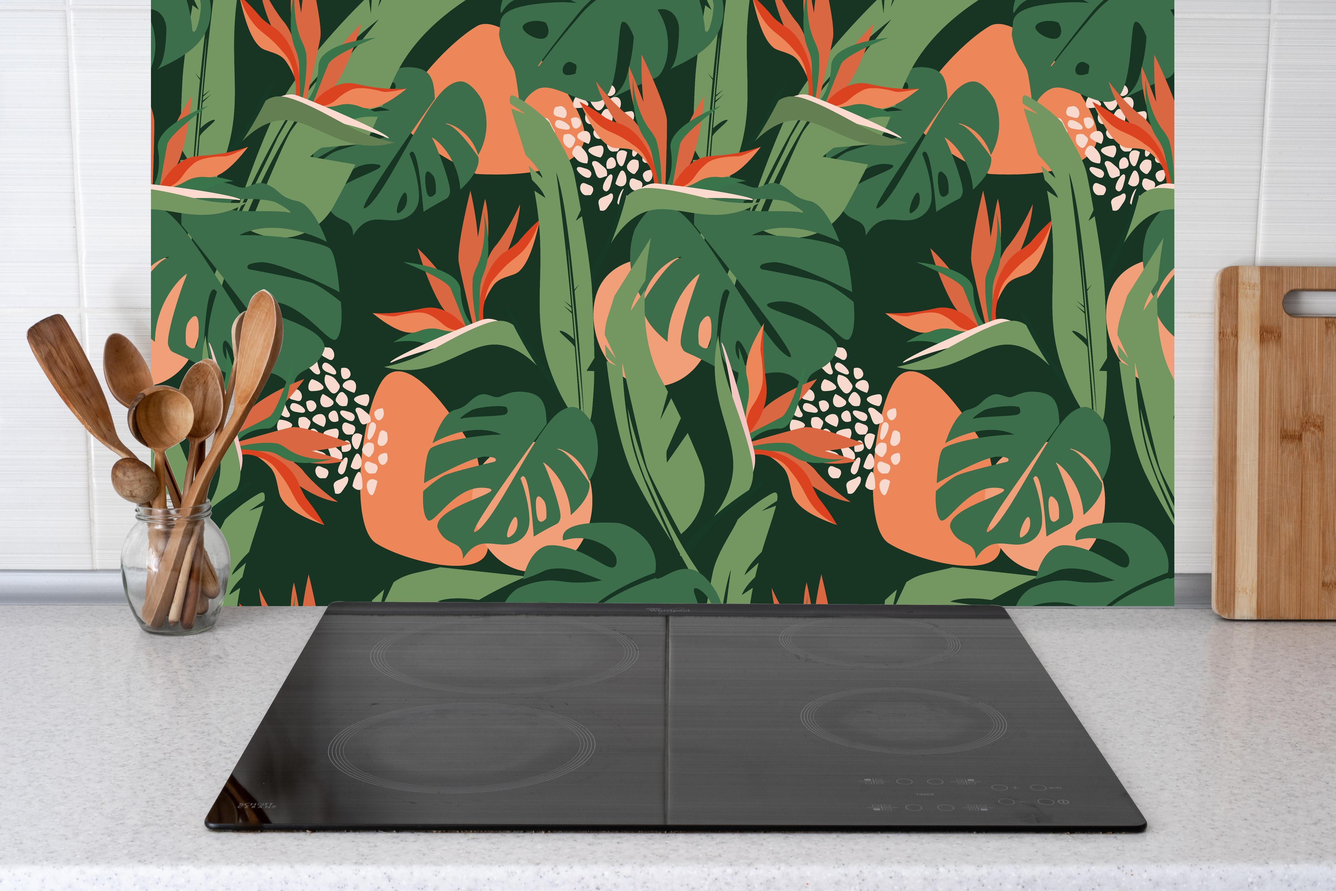 Küche - Strelitzia Tropenblatt Grün-Orange hinter Cerankochfeld und Holz-Kochutensilien