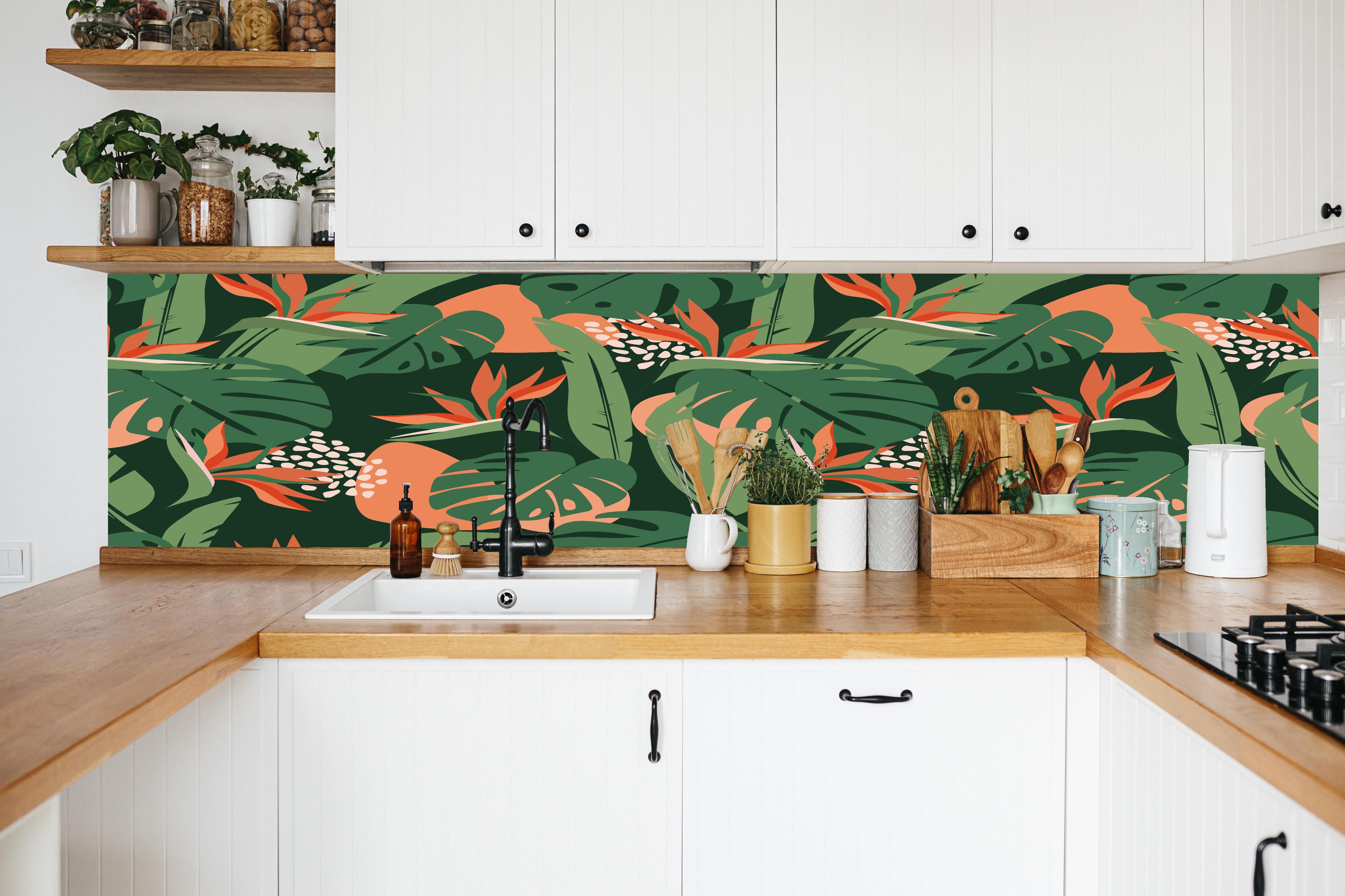 Küche - Strelitzia Tropenblatt Grün-Orange in weißer Küche hinter Gewürzen und Kochlöffeln aus Holz