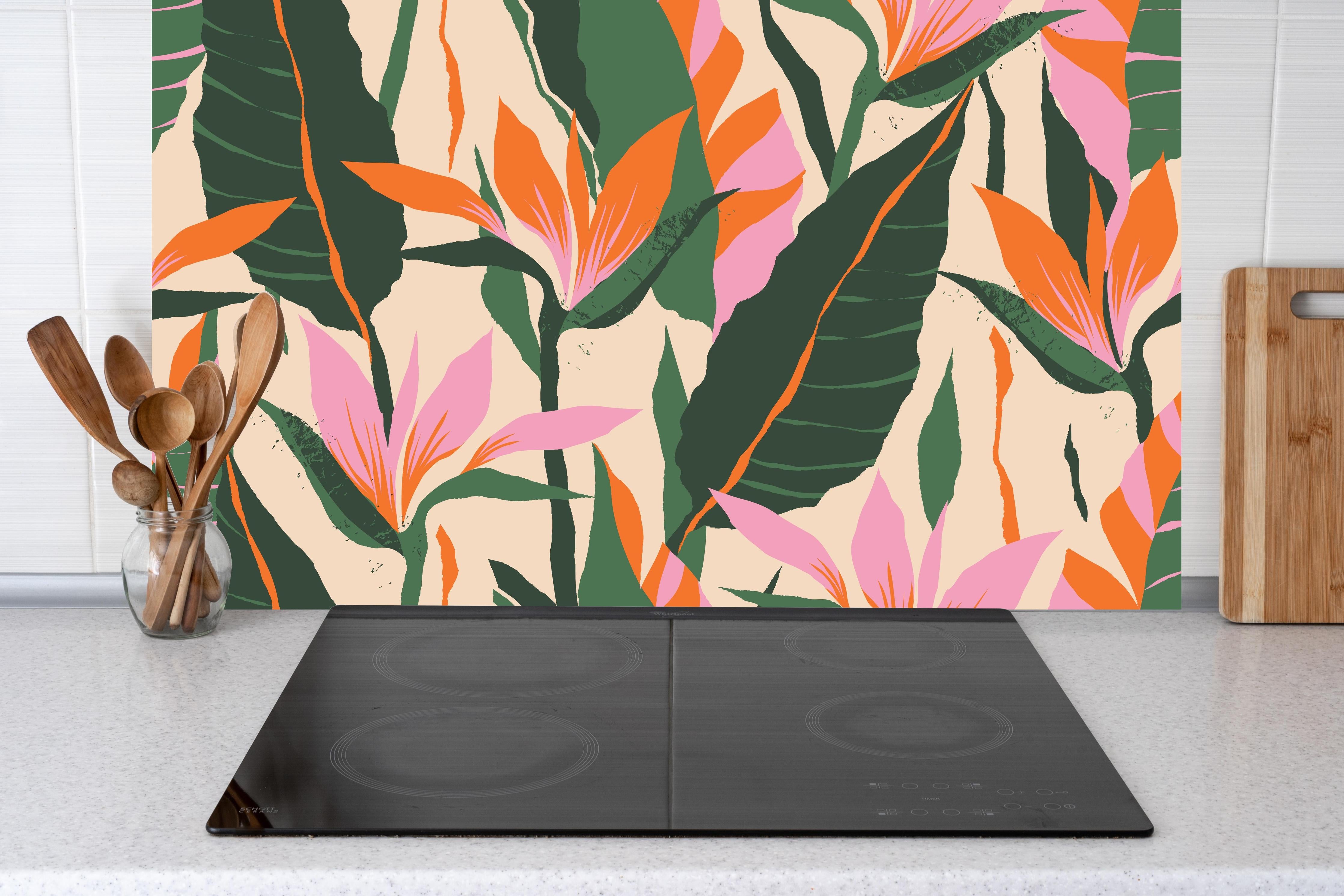 Küche - Strelitzia Tropische Blütenornamente hinter Cerankochfeld und Holz-Kochutensilien