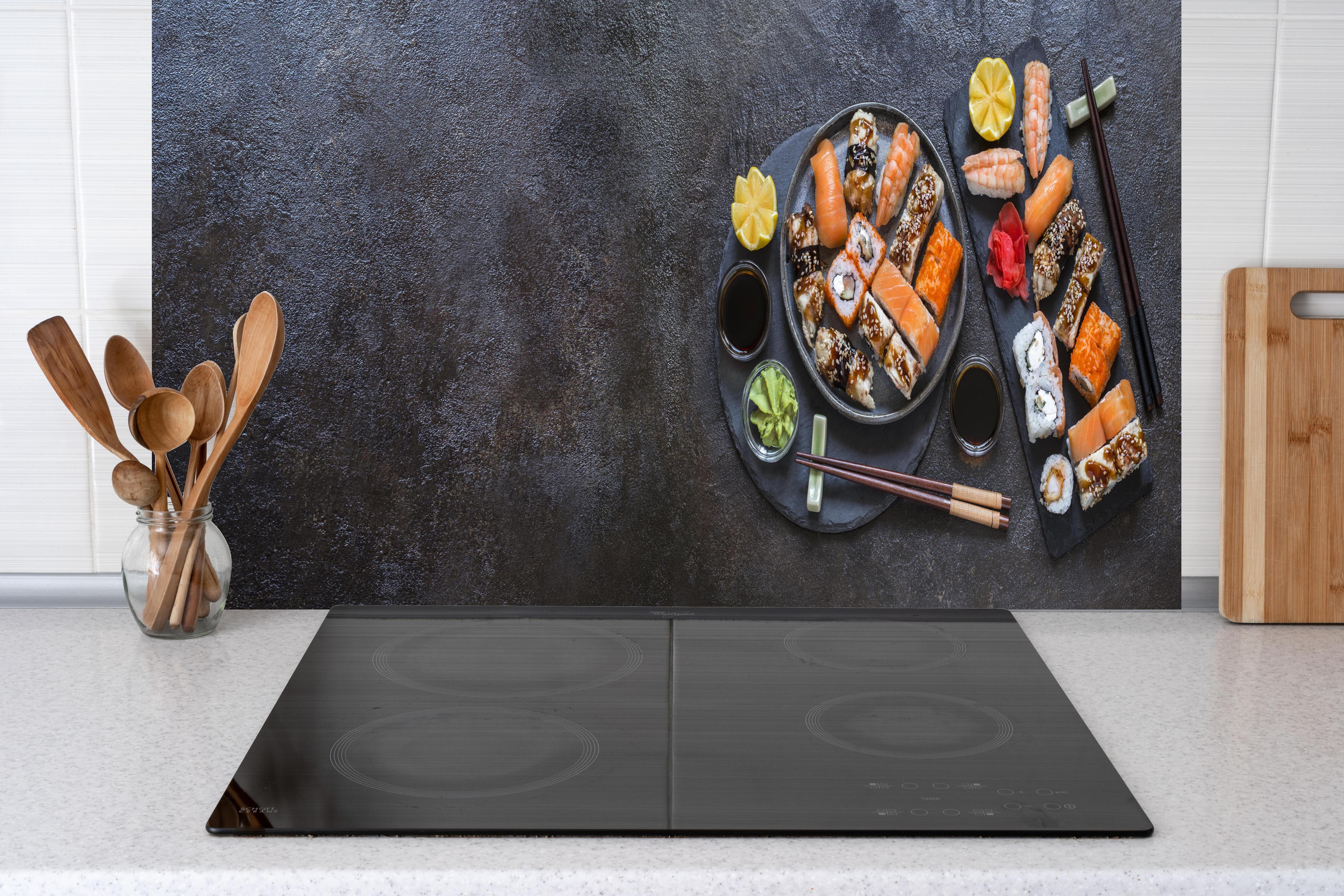Küche - Sushi-Platte Schwarz-Orange hinter Cerankochfeld und Holz-Kochutensilien