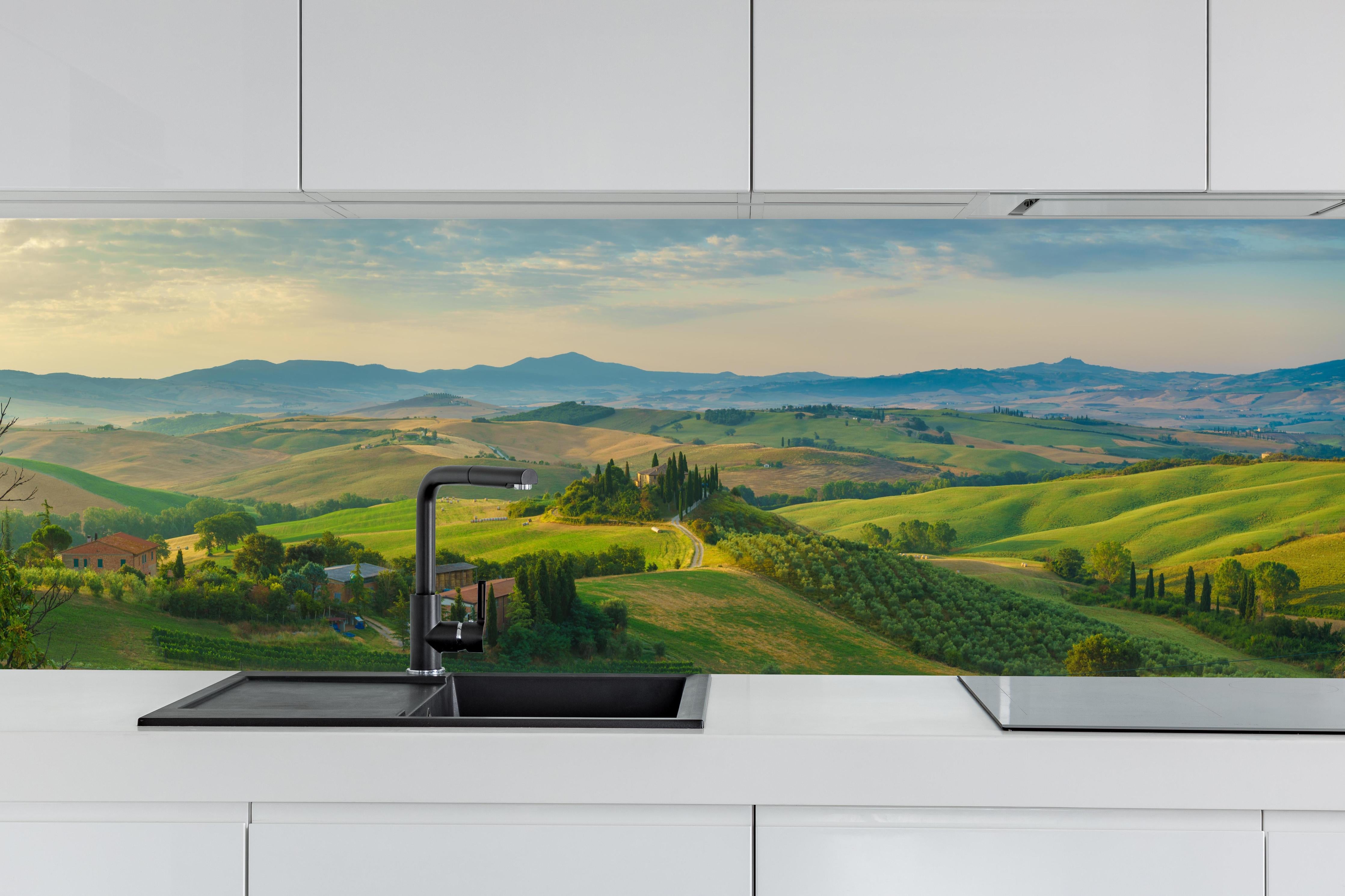 Küche - Toskana Hügellandschaft Grün-Gold hinter weißen Hochglanz-Küchenregalen und schwarzem Wasserhahn