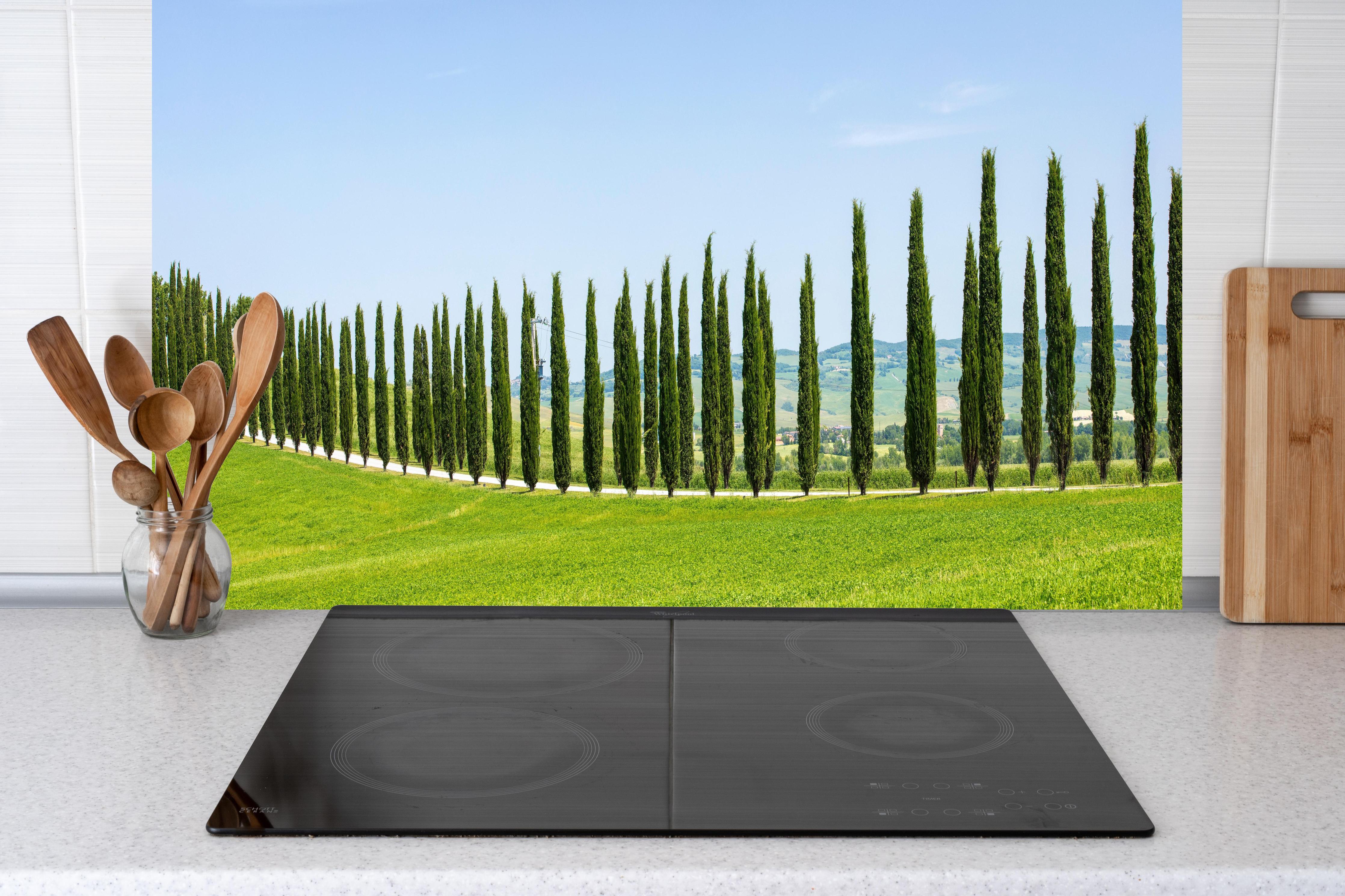 Küche - Toskanische Zypressenallee hinter Cerankochfeld und Holz-Kochutensilien