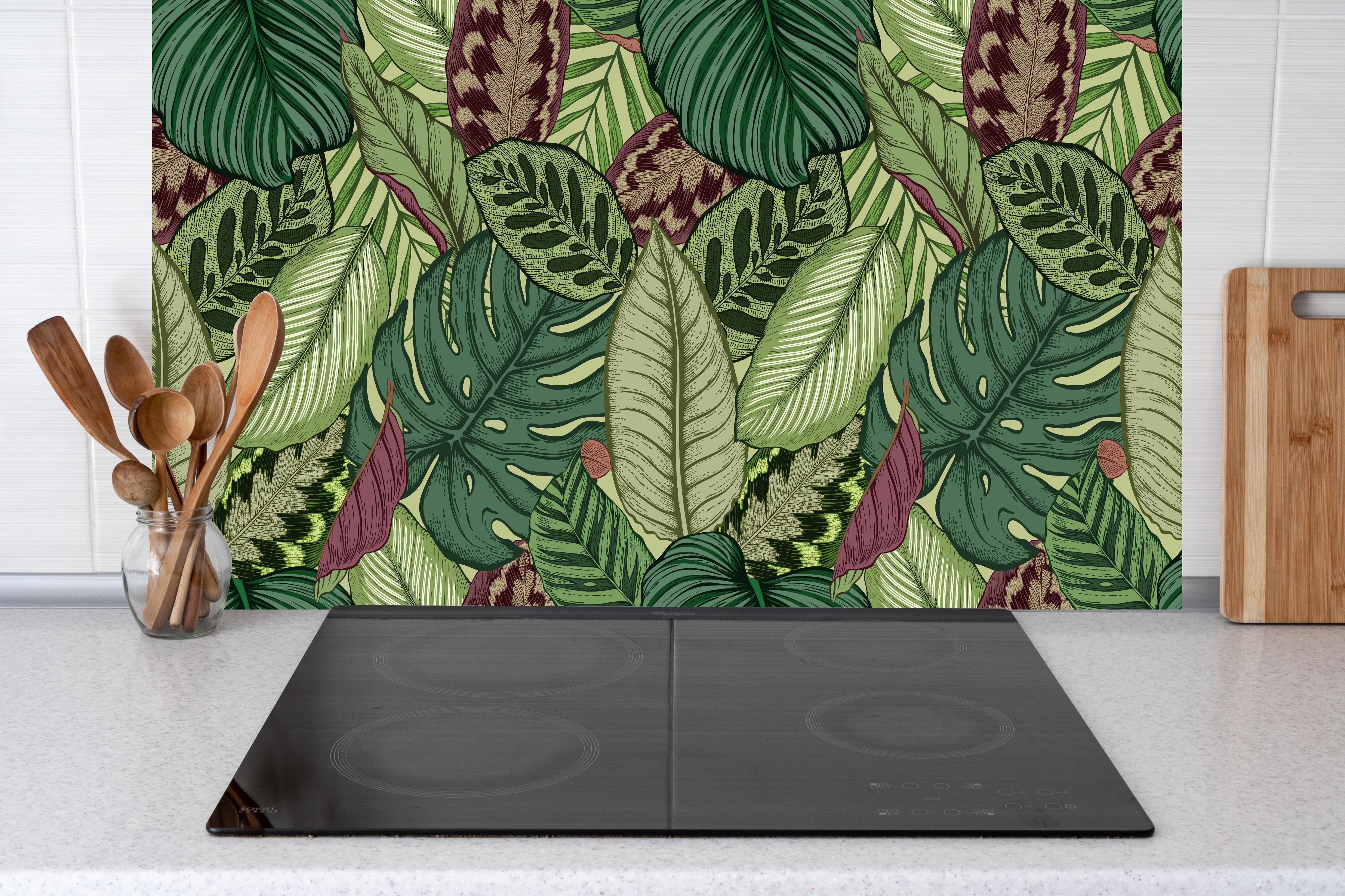 Küche - Tropische Blätter Grün-Beige hinter Cerankochfeld und Holz-Kochutensilien