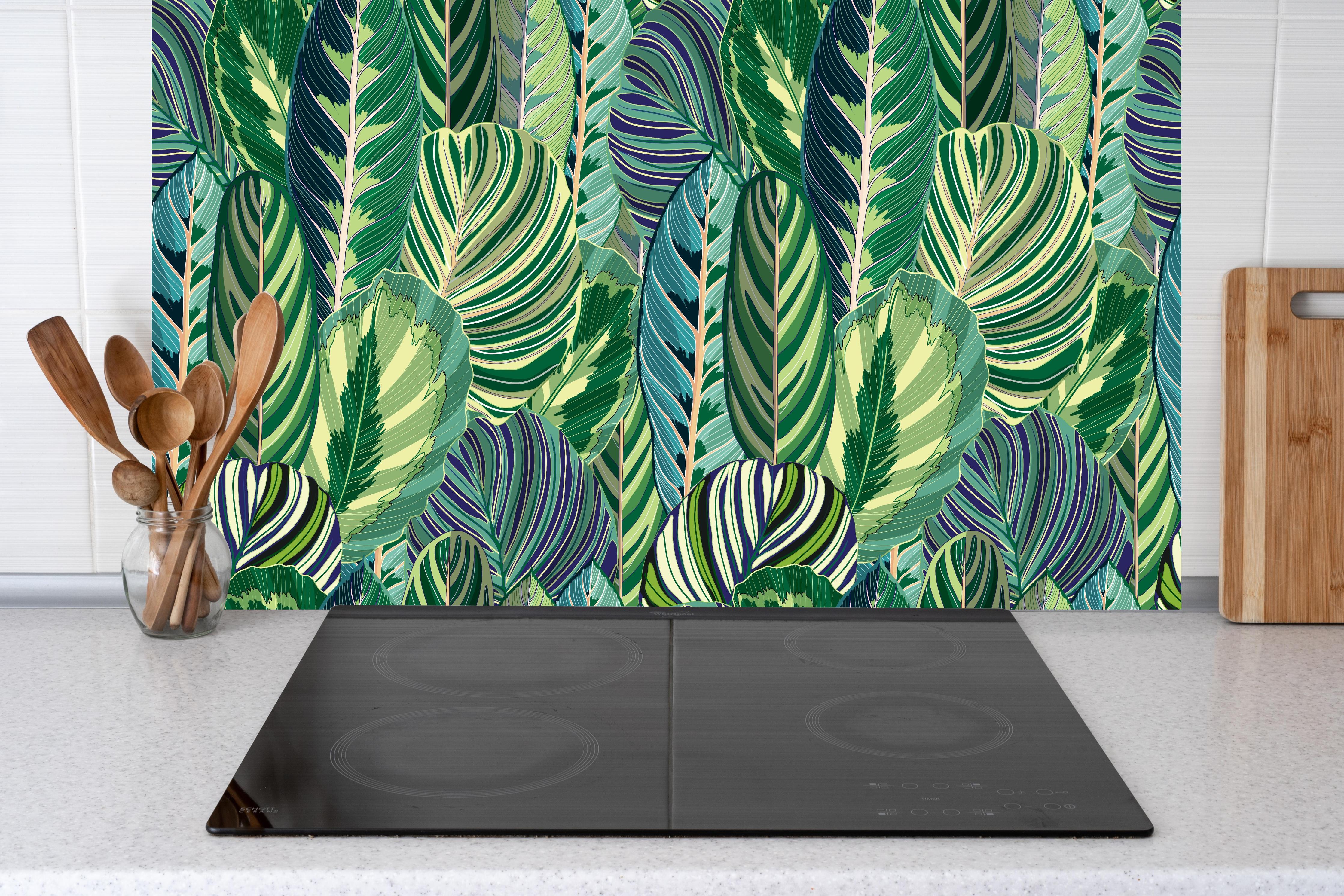 Küche - Tropische Blätter Grün-Türkis-Lila hinter Cerankochfeld und Holz-Kochutensilien