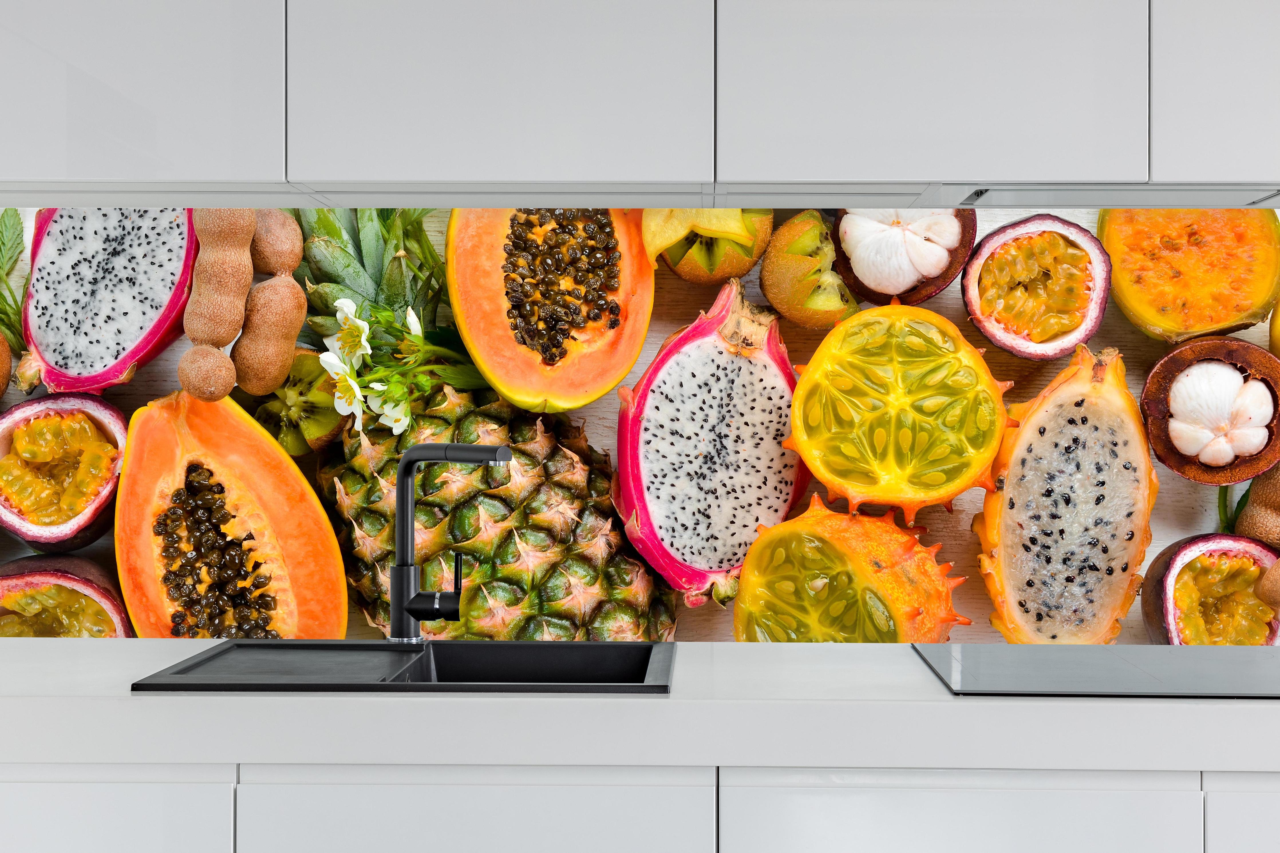 Küche - Tropische Früchte Collage Orange Gelb hinter weißen Hochglanz-Küchenregalen und schwarzem Wasserhahn