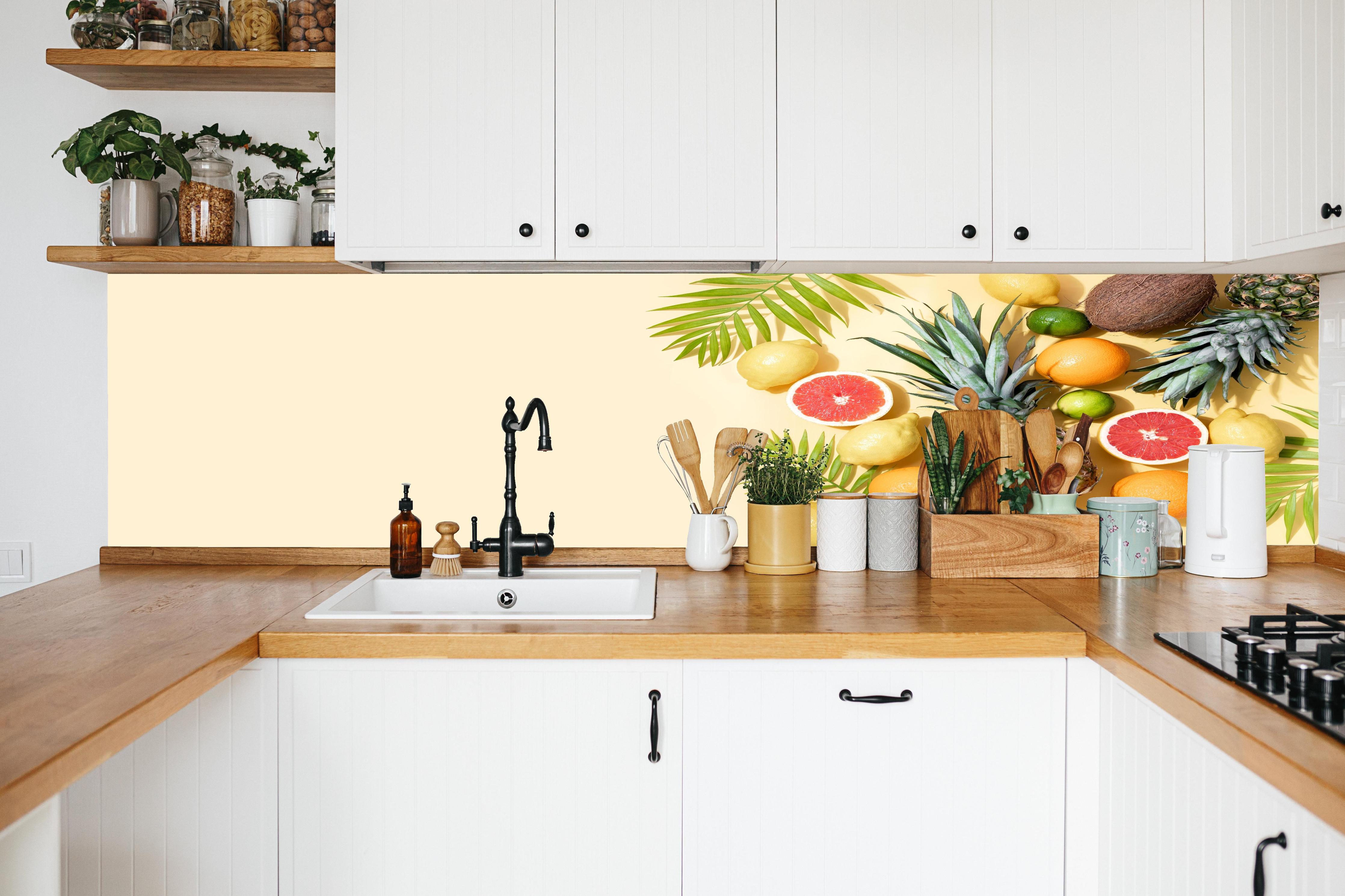 Küche - Tropische Früchte auf Beige in weißer Küche hinter Gewürzen und Kochlöffeln aus Holz