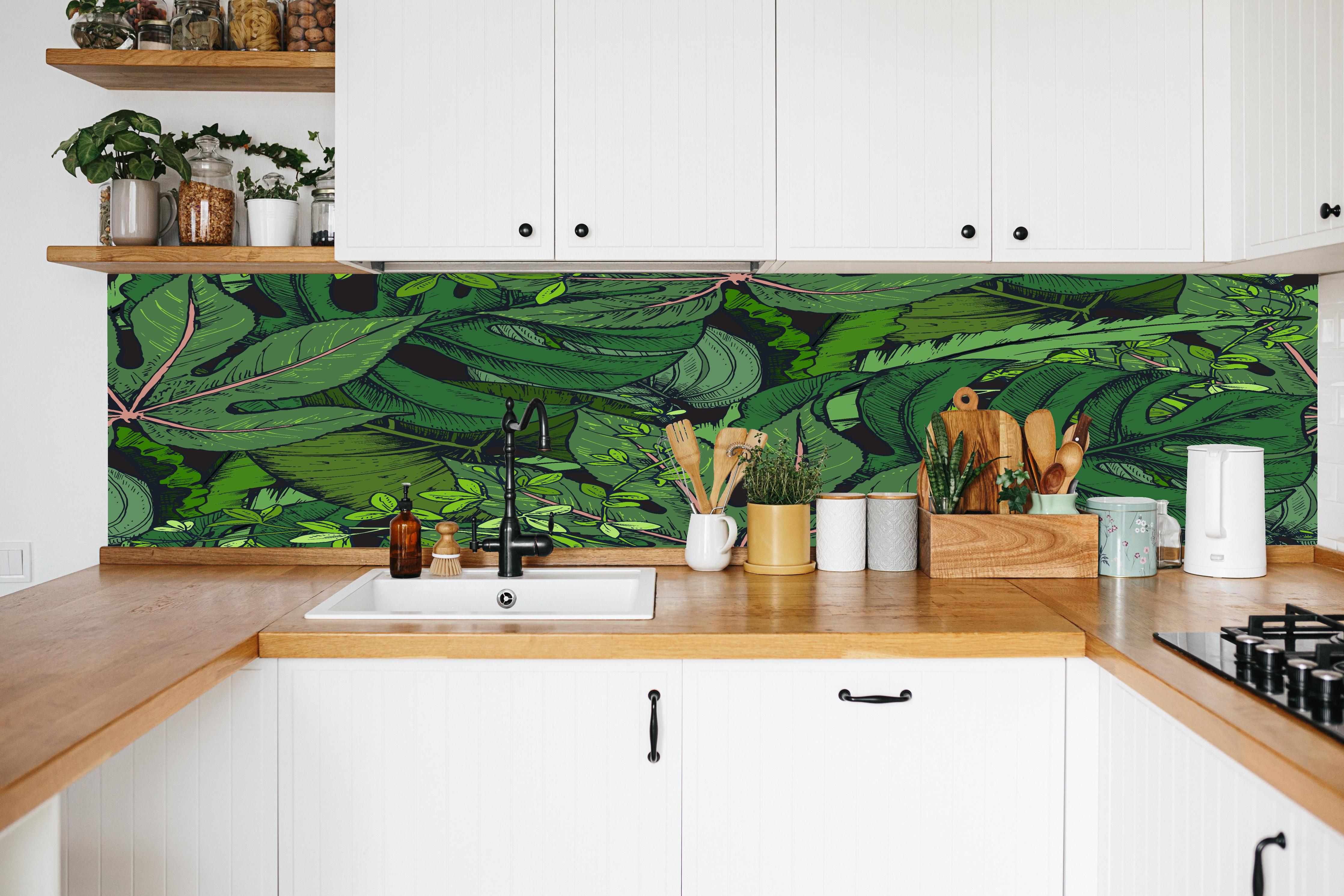 Küche - Tropische Monstera-Blätter Grün in weißer Küche hinter Gewürzen und Kochlöffeln aus Holz