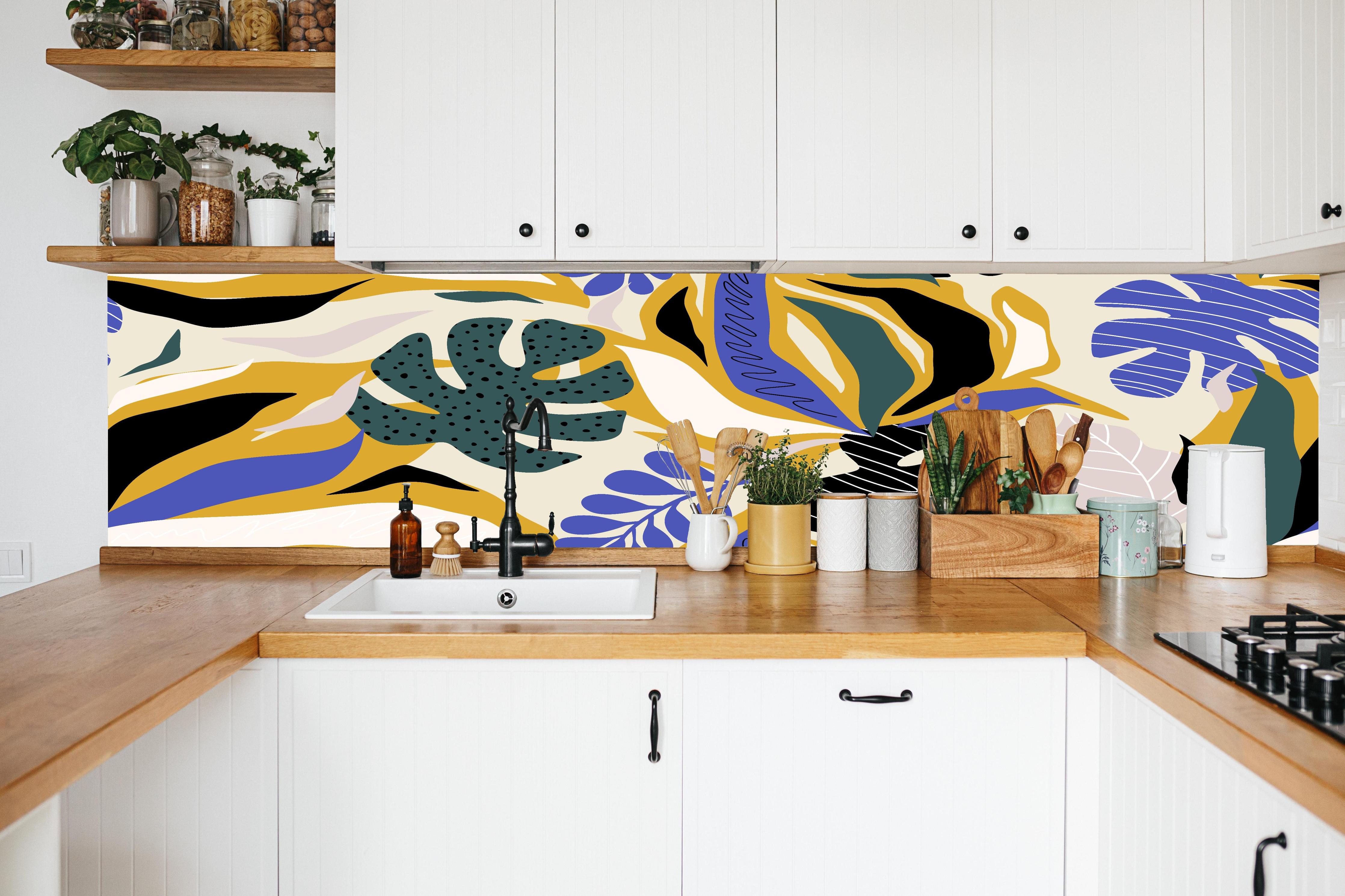 Küche - Tropisches Blattmuster Gelb-Blau in weißer Küche hinter Gewürzen und Kochlöffeln aus Holz