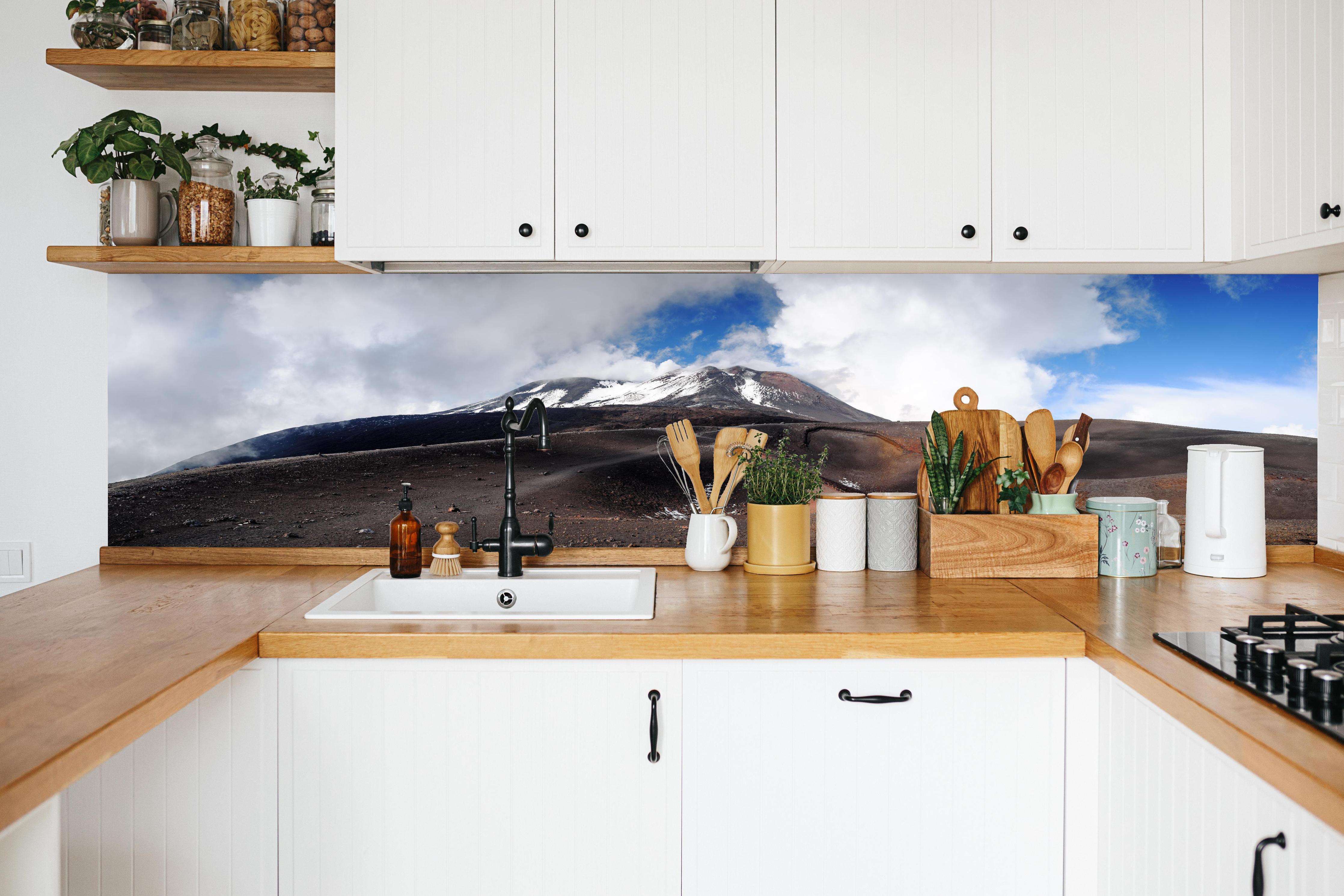Küche - Vulkan-Panorama Braun-Grau-Blau in weißer Küche hinter Gewürzen und Kochlöffeln aus Holz