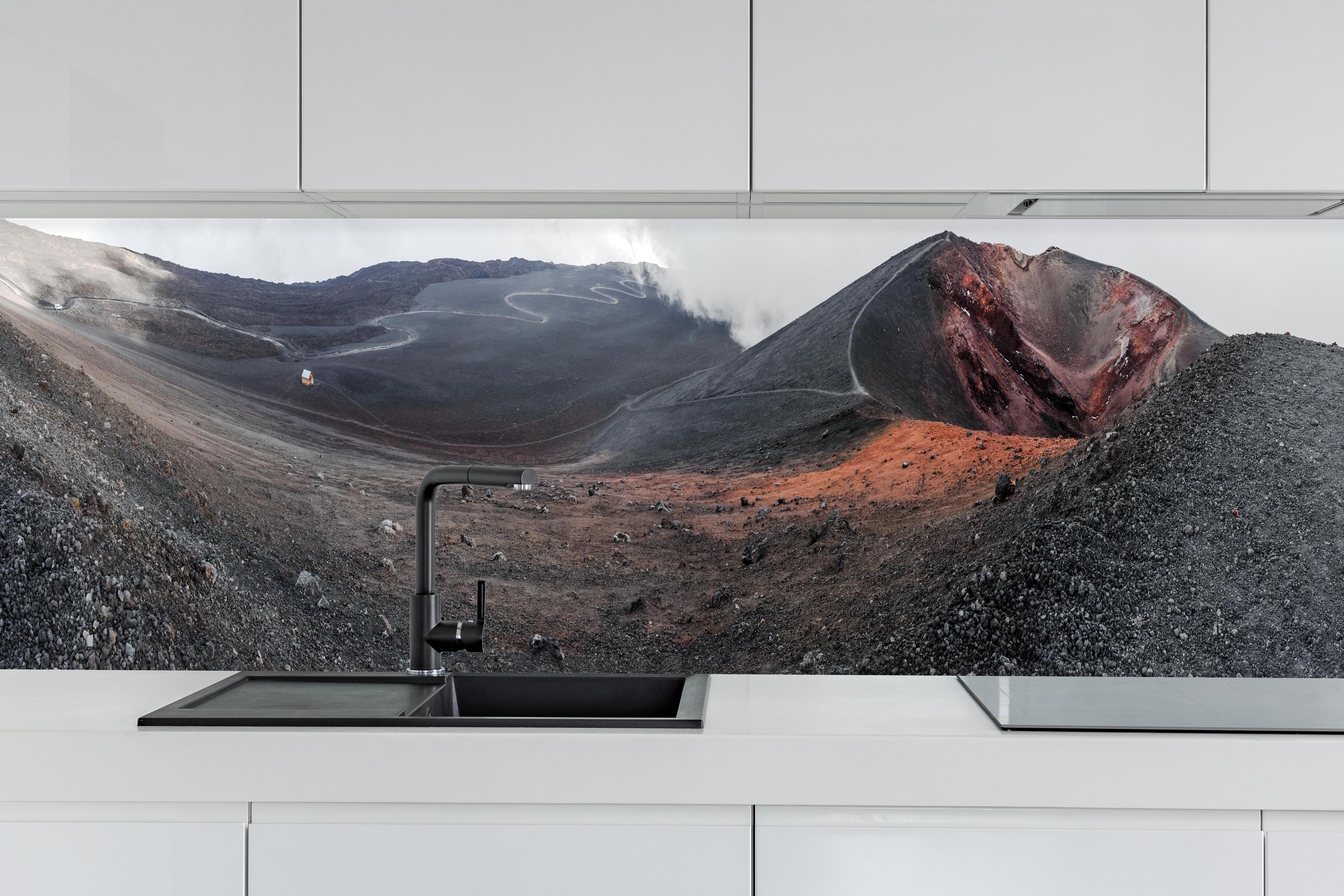 Küche - Vulkankrater Schwarz-Grau-Orange Panorama hinter weißen Hochglanz-Küchenregalen und schwarzem Wasserhahn