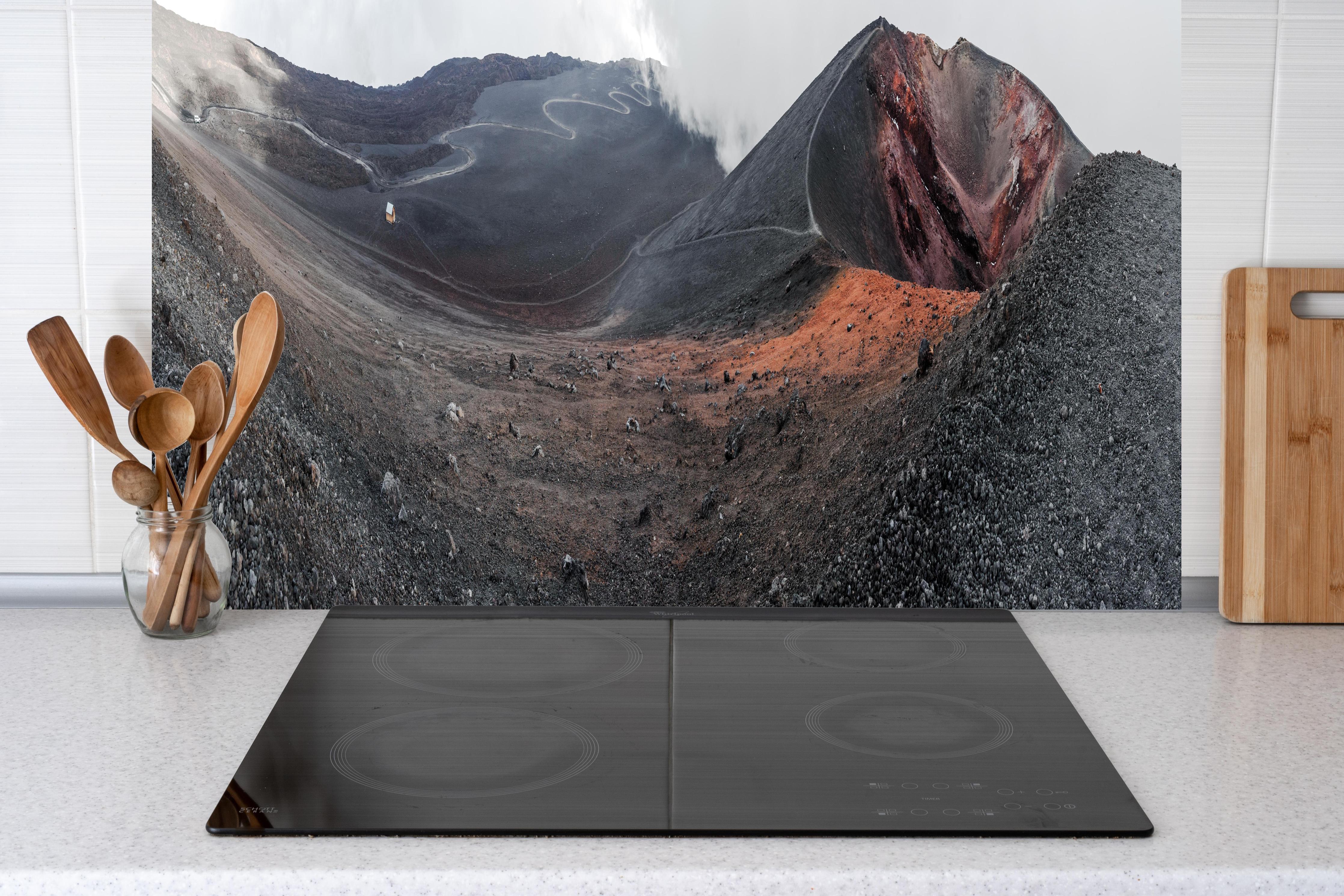 Küche - Vulkankrater Schwarz-Grau-Orange Panorama hinter Cerankochfeld und Holz-Kochutensilien