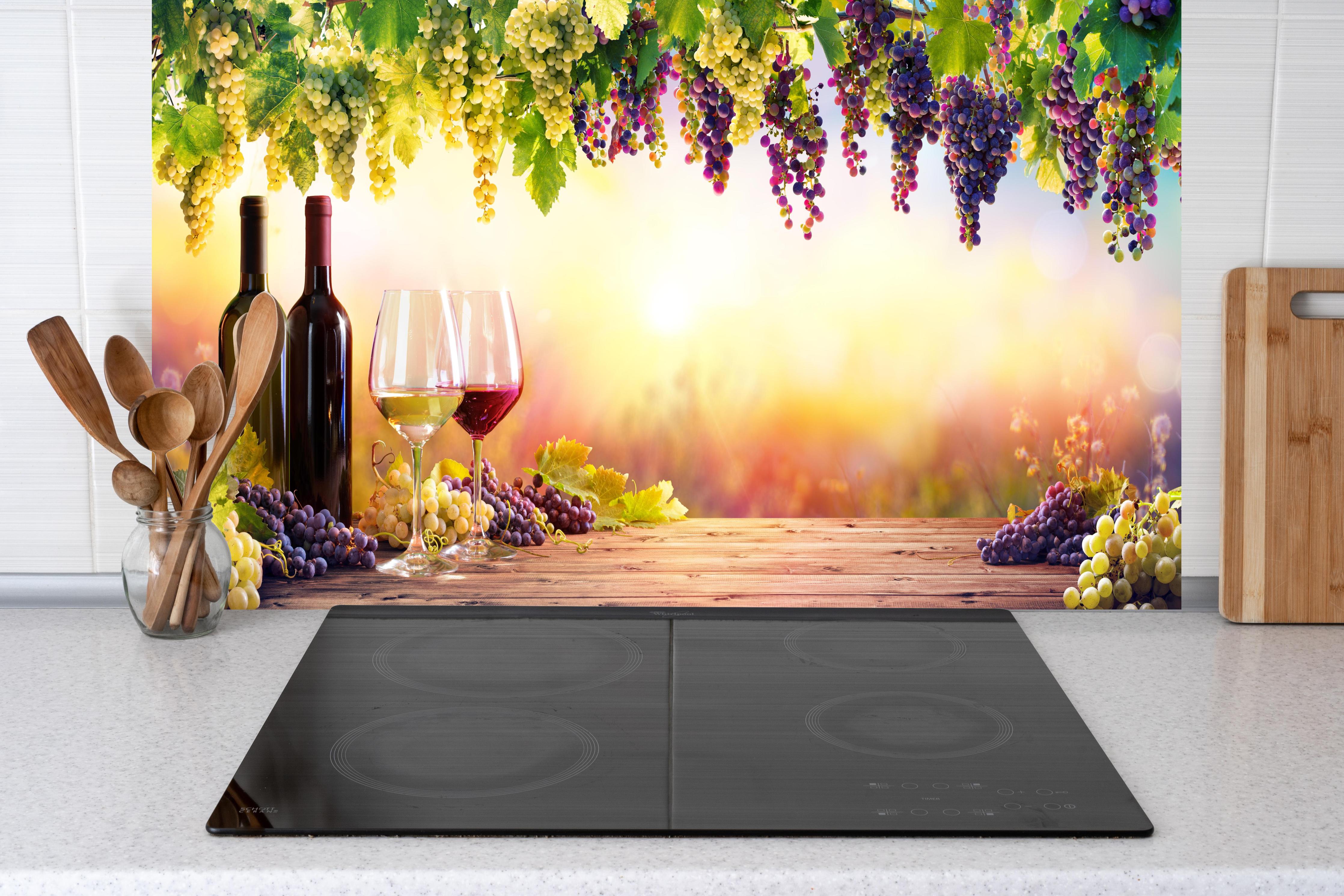 Küche - Weintrauben und Sonnenuntergang hinter Cerankochfeld und Holz-Kochutensilien