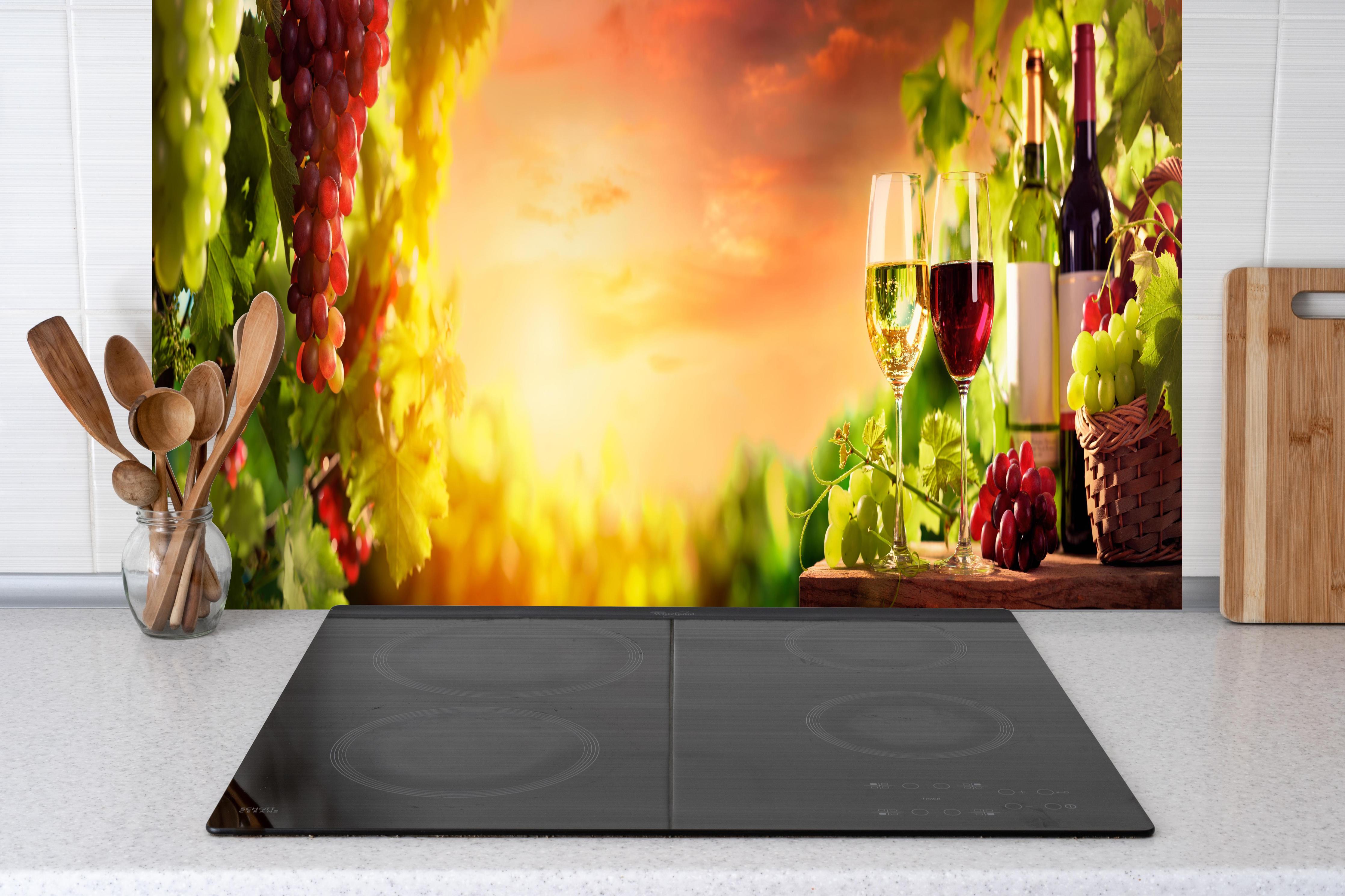 Küche - Weintrauben und Wein im Sonnenuntergang hinter Cerankochfeld und Holz-Kochutensilien