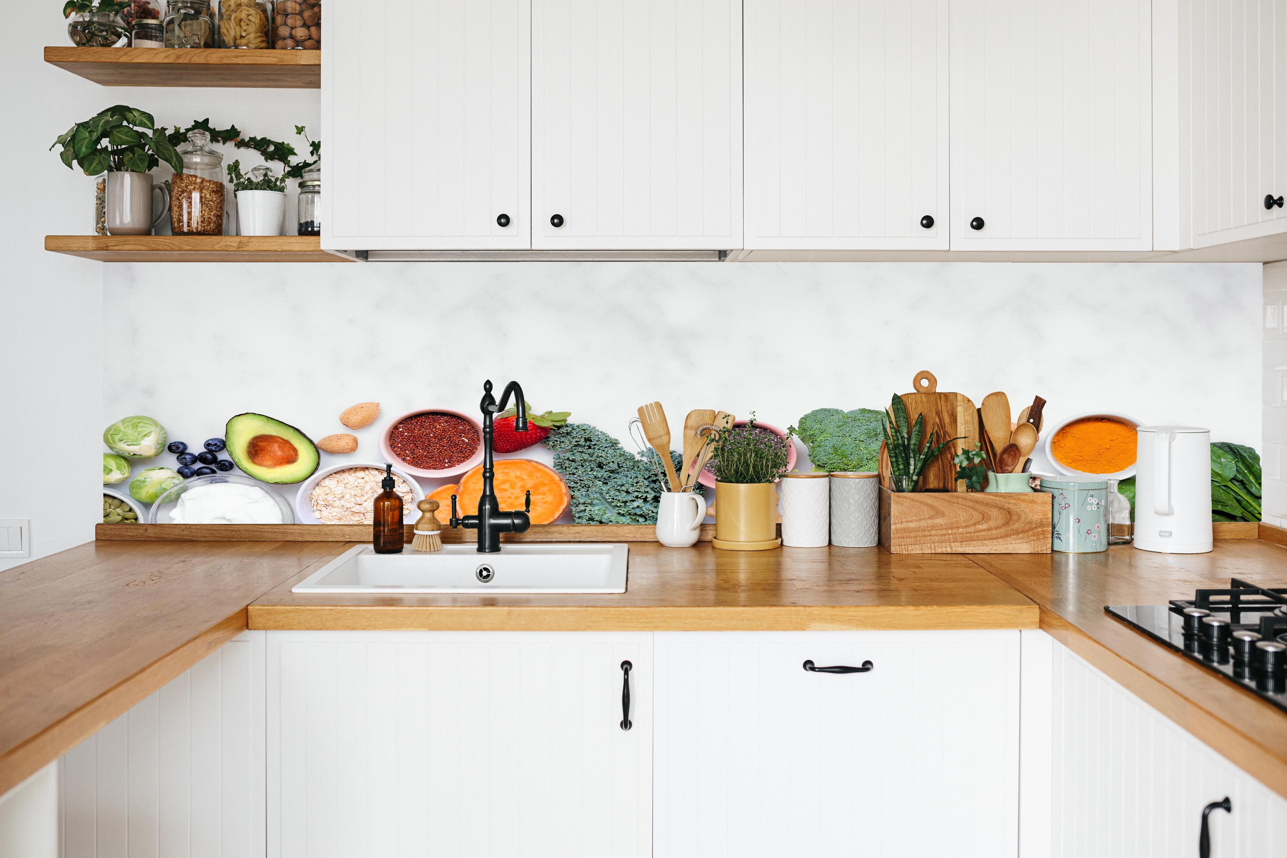 Küche - Weiß-Grün-Orange Küchenstillleben in weißer Küche hinter Gewürzen und Kochlöffeln aus Holz