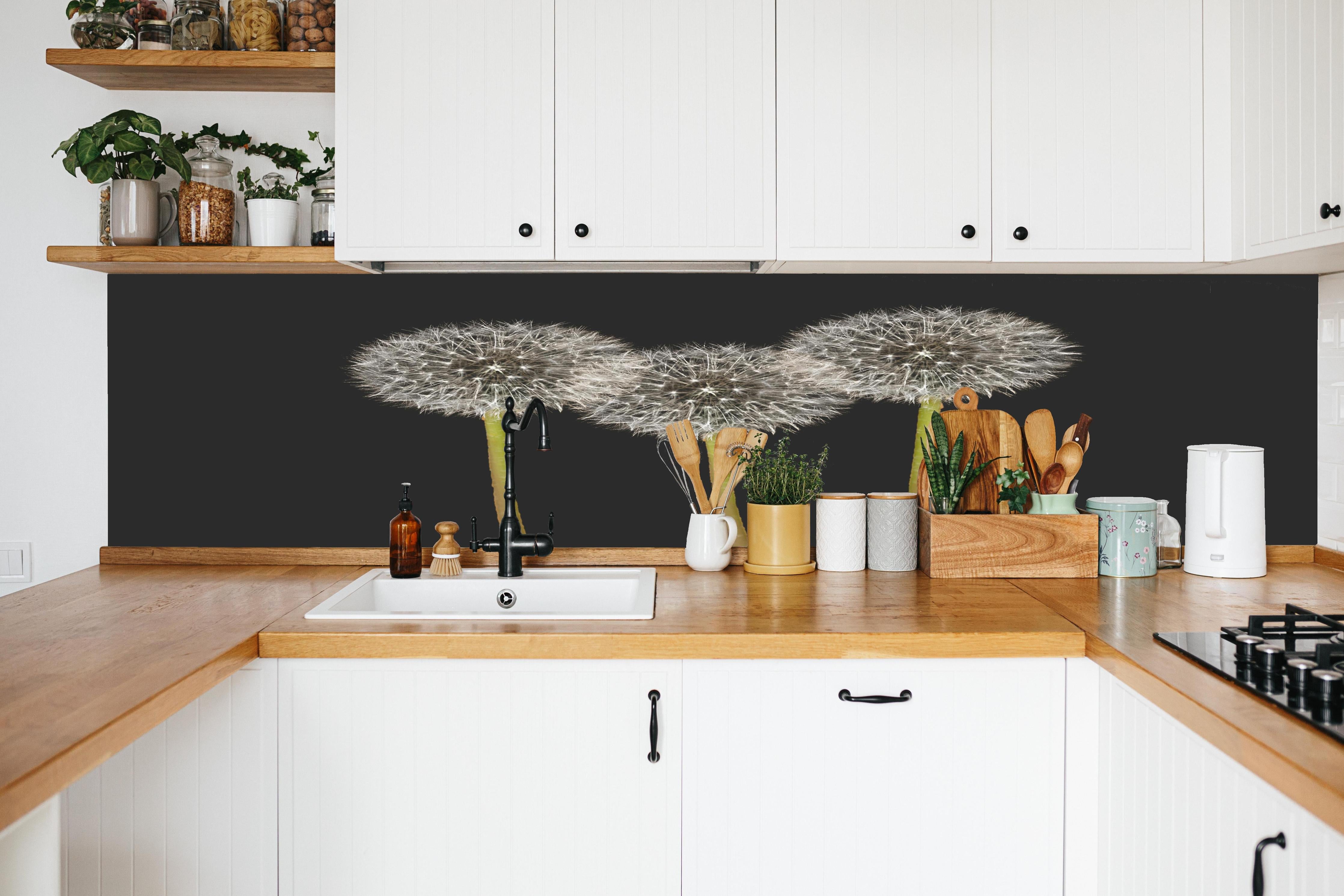Küche - Weiße Pusteblumen auf Schwarz in weißer Küche hinter Gewürzen und Kochlöffeln aus Holz
