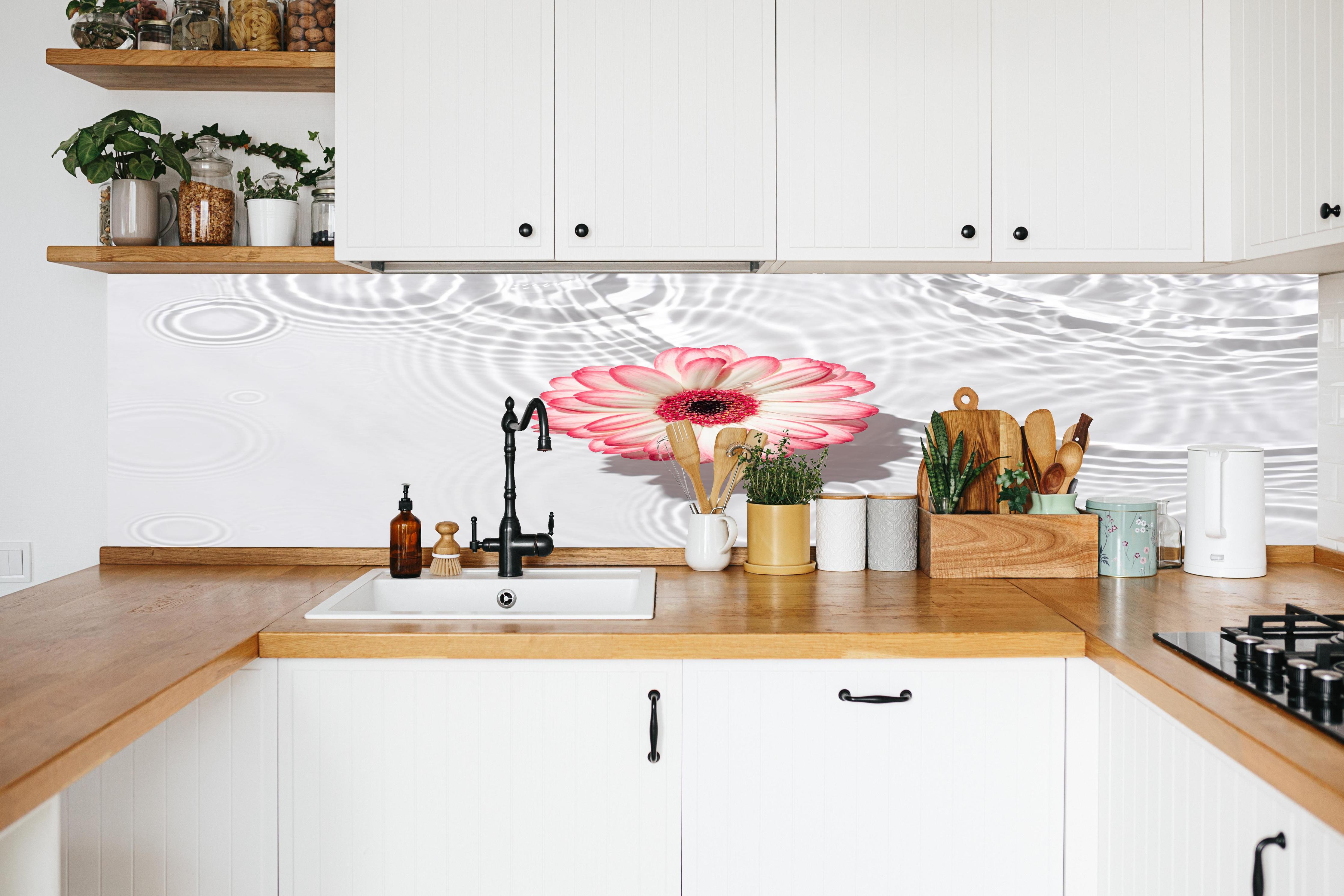Küche - Weiße Wasserblume in Rosa in weißer Küche hinter Gewürzen und Kochlöffeln aus Holz