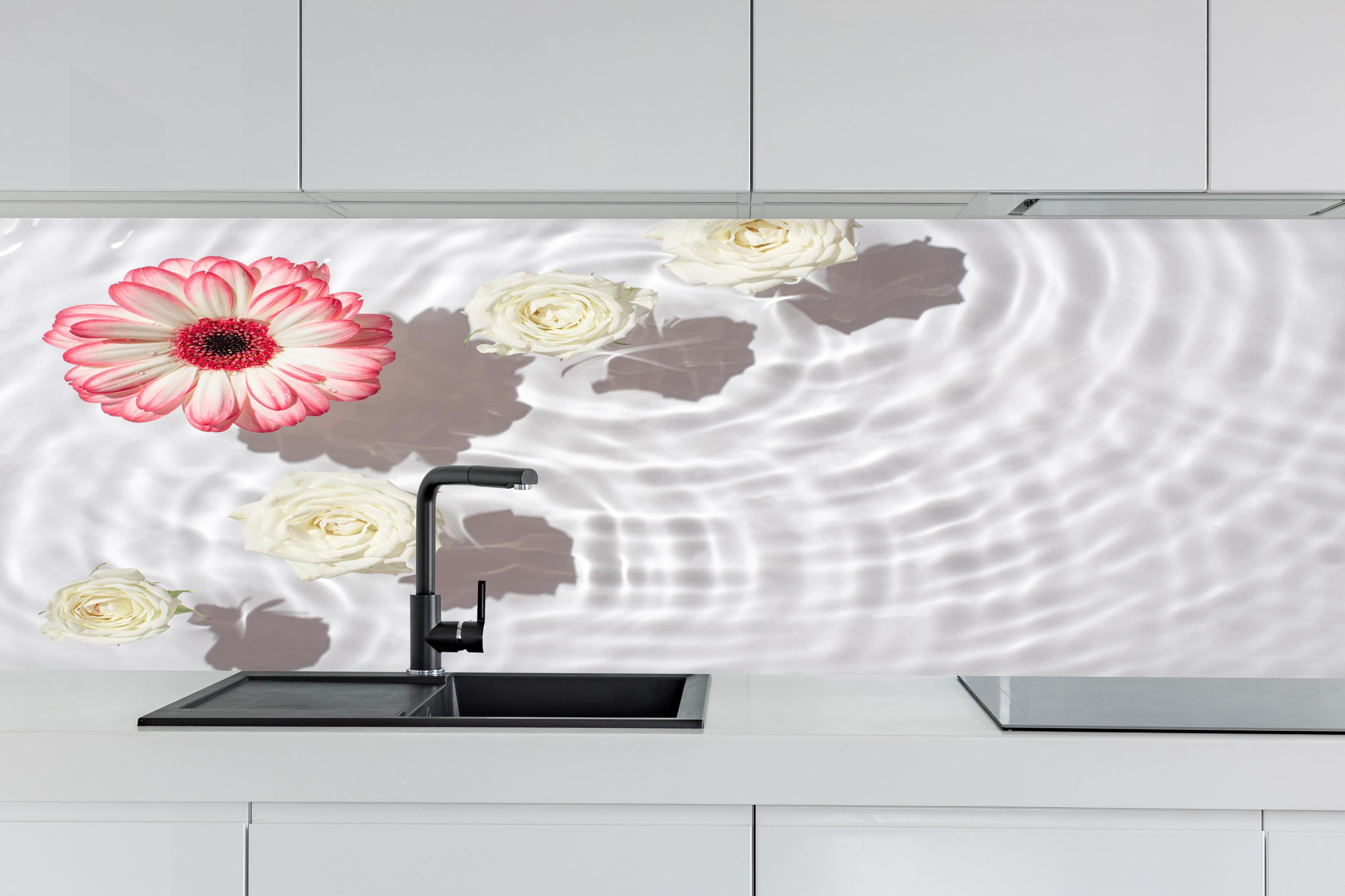 Küche - Weiße Wasserblumen mit Rosa-Akzent hinter weißen Hochglanz-Küchenregalen und schwarzem Wasserhahn