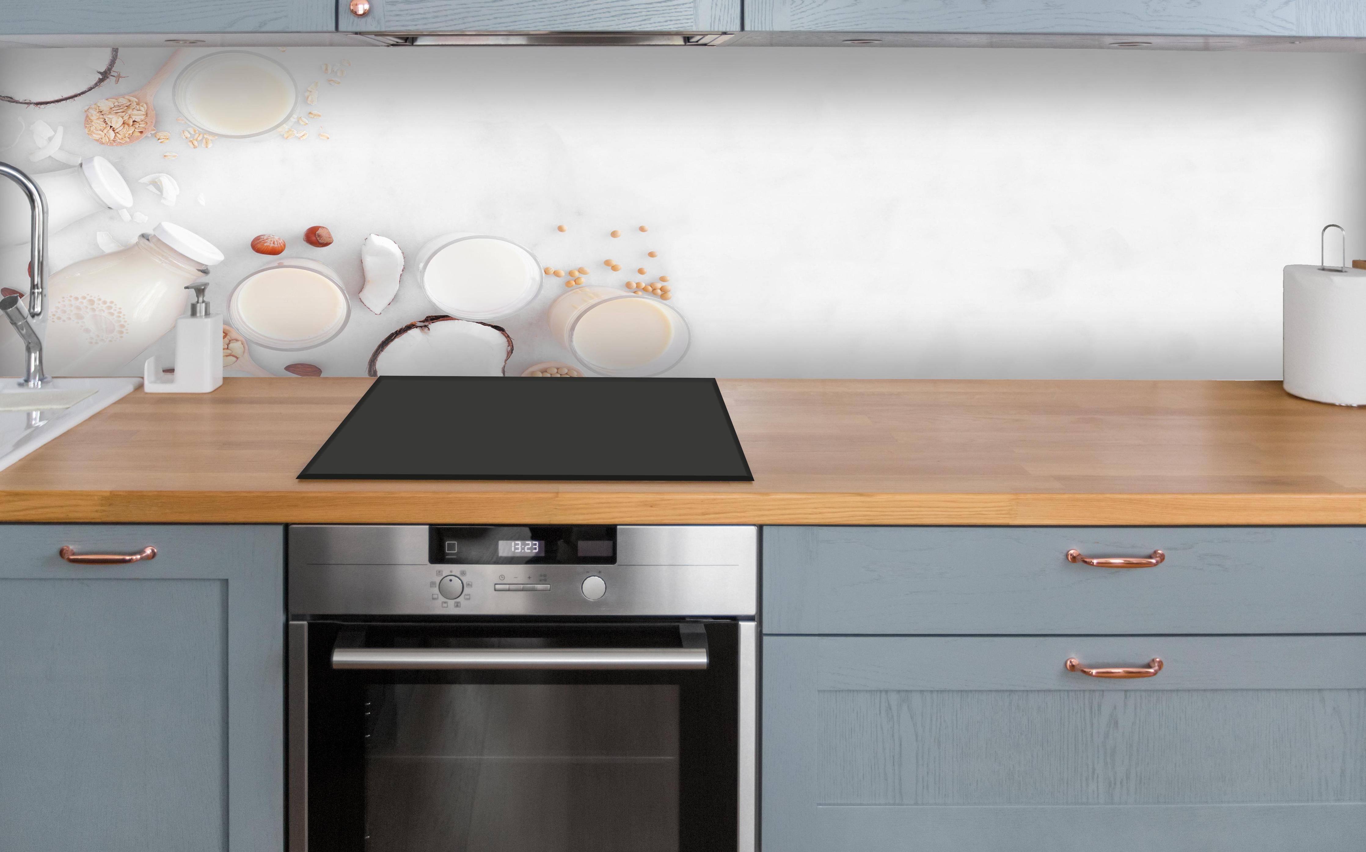 Küche - Weißes Pflanzenmilch-Stillleben über polierter Holzarbeitsplatte mit Cerankochfeld