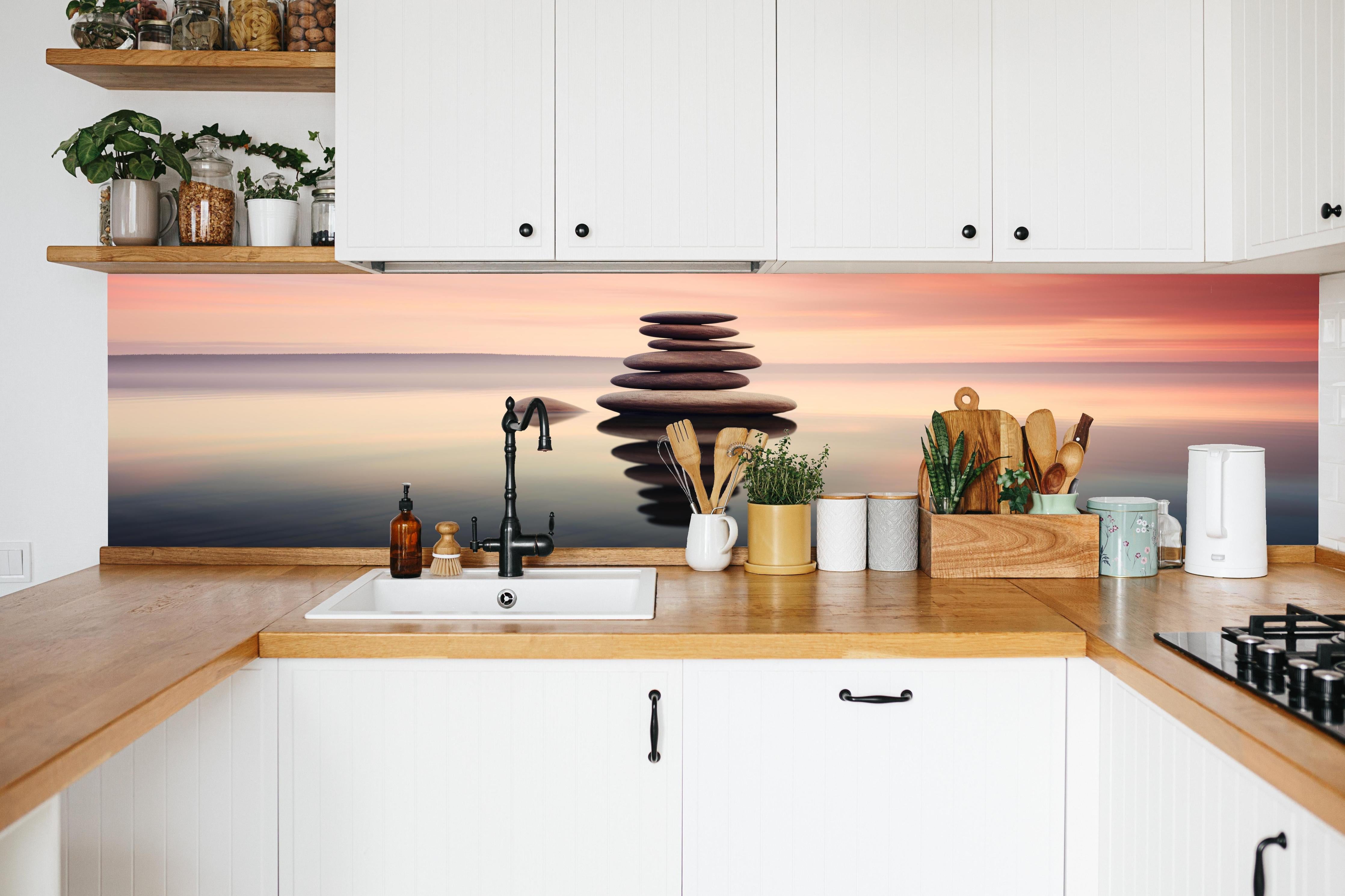 Küche - Zen-Steine am rosa Sonnenuntergang in weißer Küche hinter Gewürzen und Kochlöffeln aus Holz