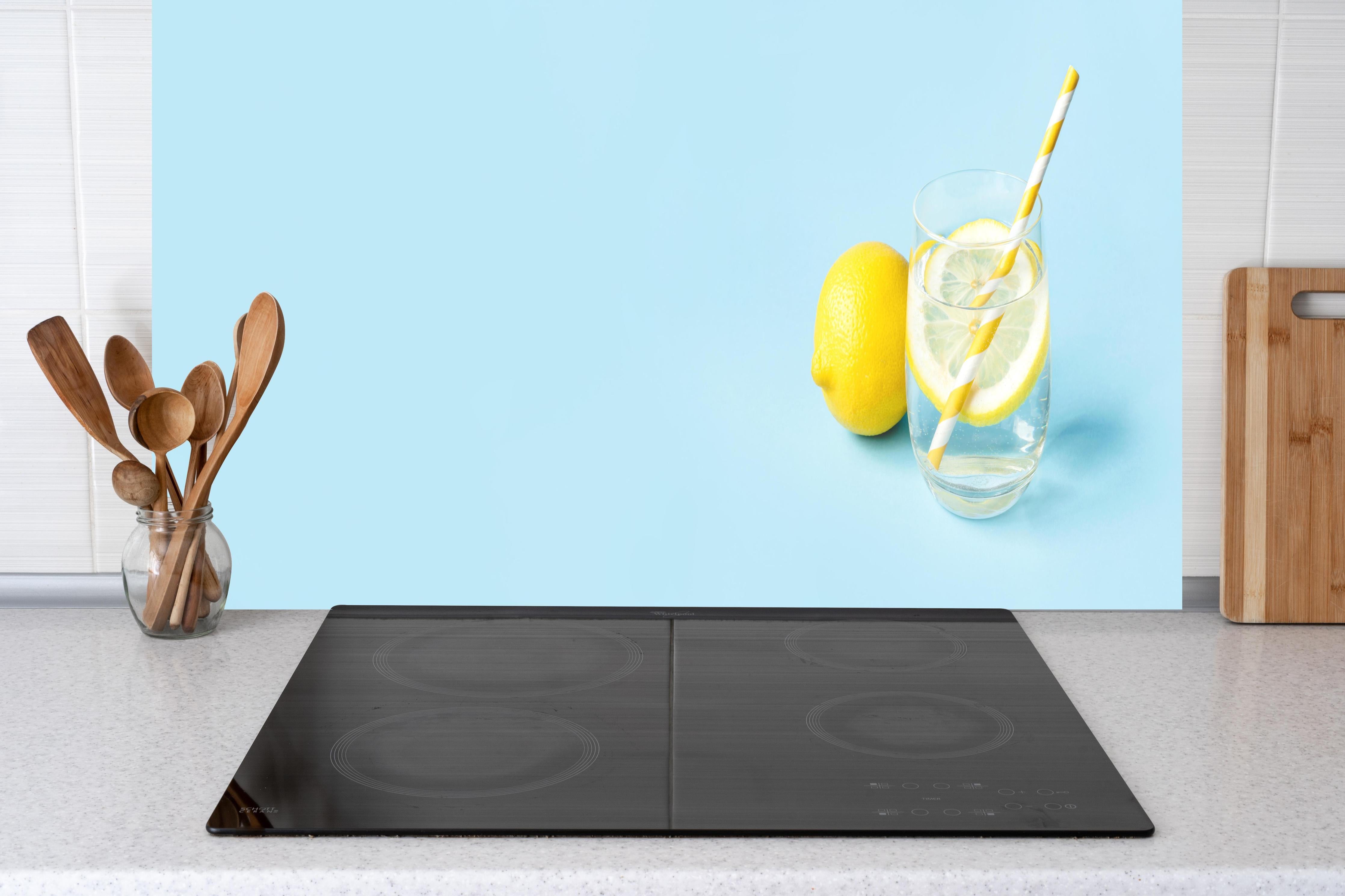 Küche - Zitrone Limette auf Blau hinter Cerankochfeld und Holz-Kochutensilien