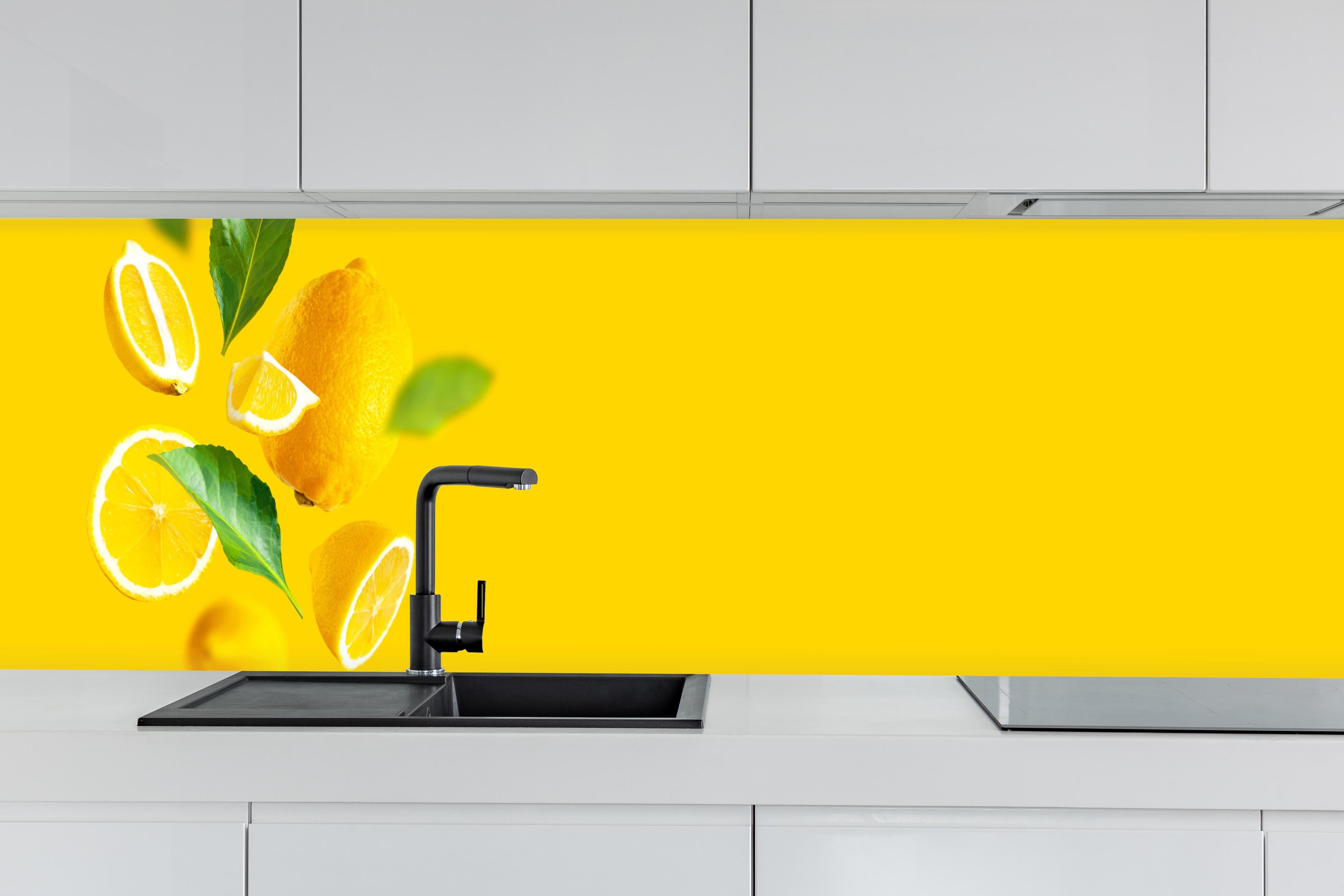 Küche - Zitronen Limetten Gelber Hintergrund hinter weißen Hochglanz-Küchenregalen und schwarzem Wasserhahn