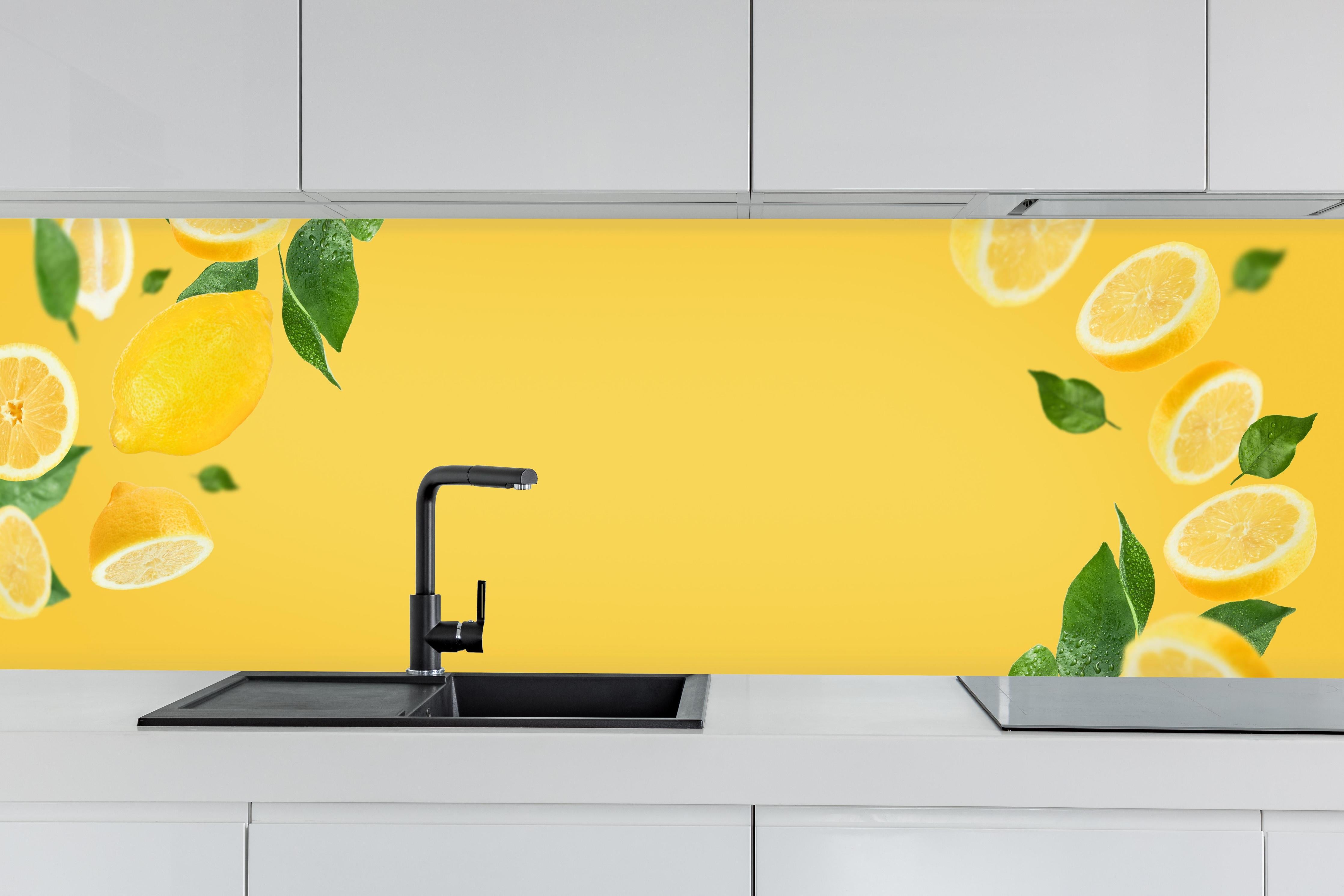 Küche - Zitronen-Limetten Gelber Rahmen hinter weißen Hochglanz-Küchenregalen und schwarzem Wasserhahn