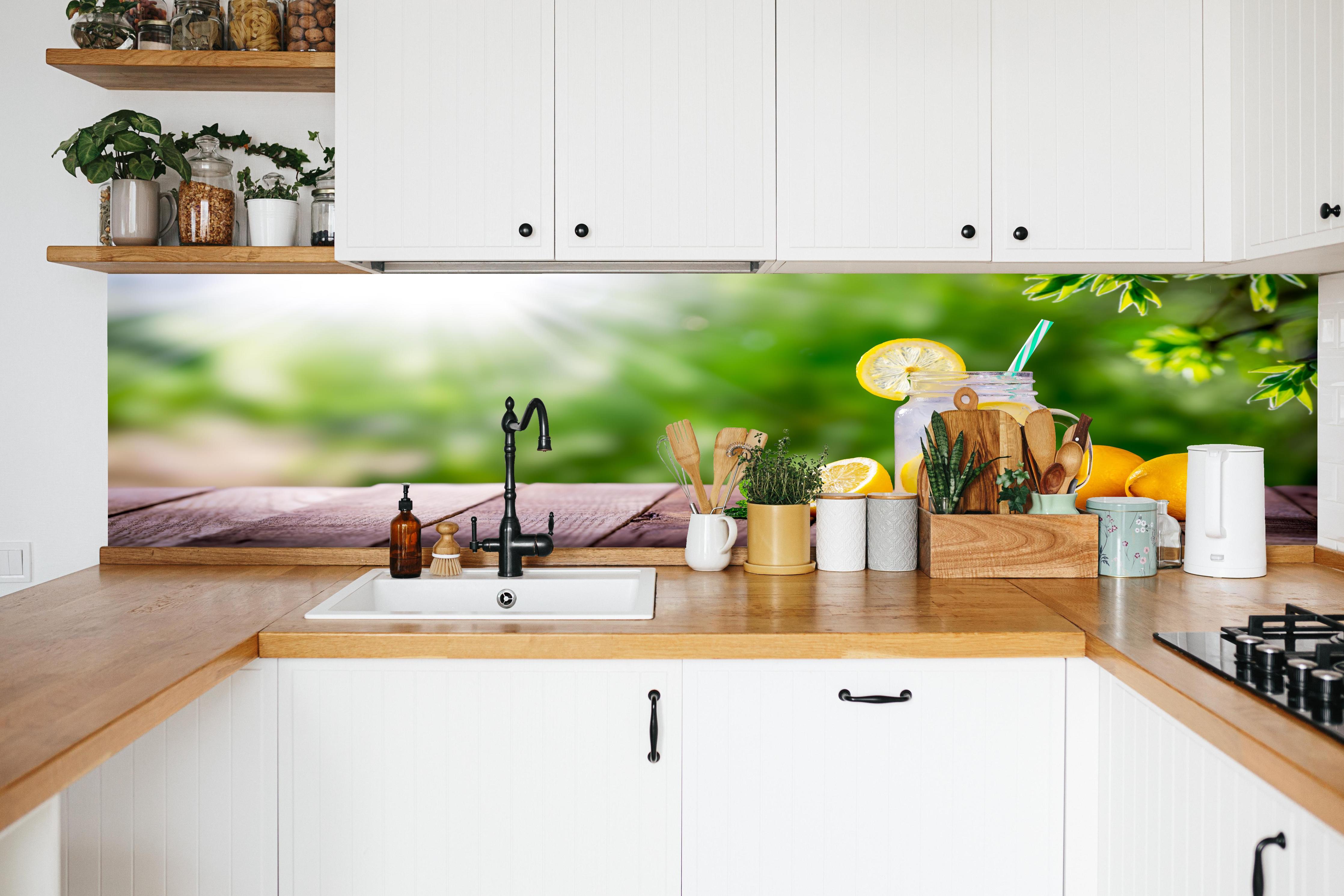 Küche - Zitronen-Limonade auf Holztisch in weißer Küche hinter Gewürzen und Kochlöffeln aus Holz