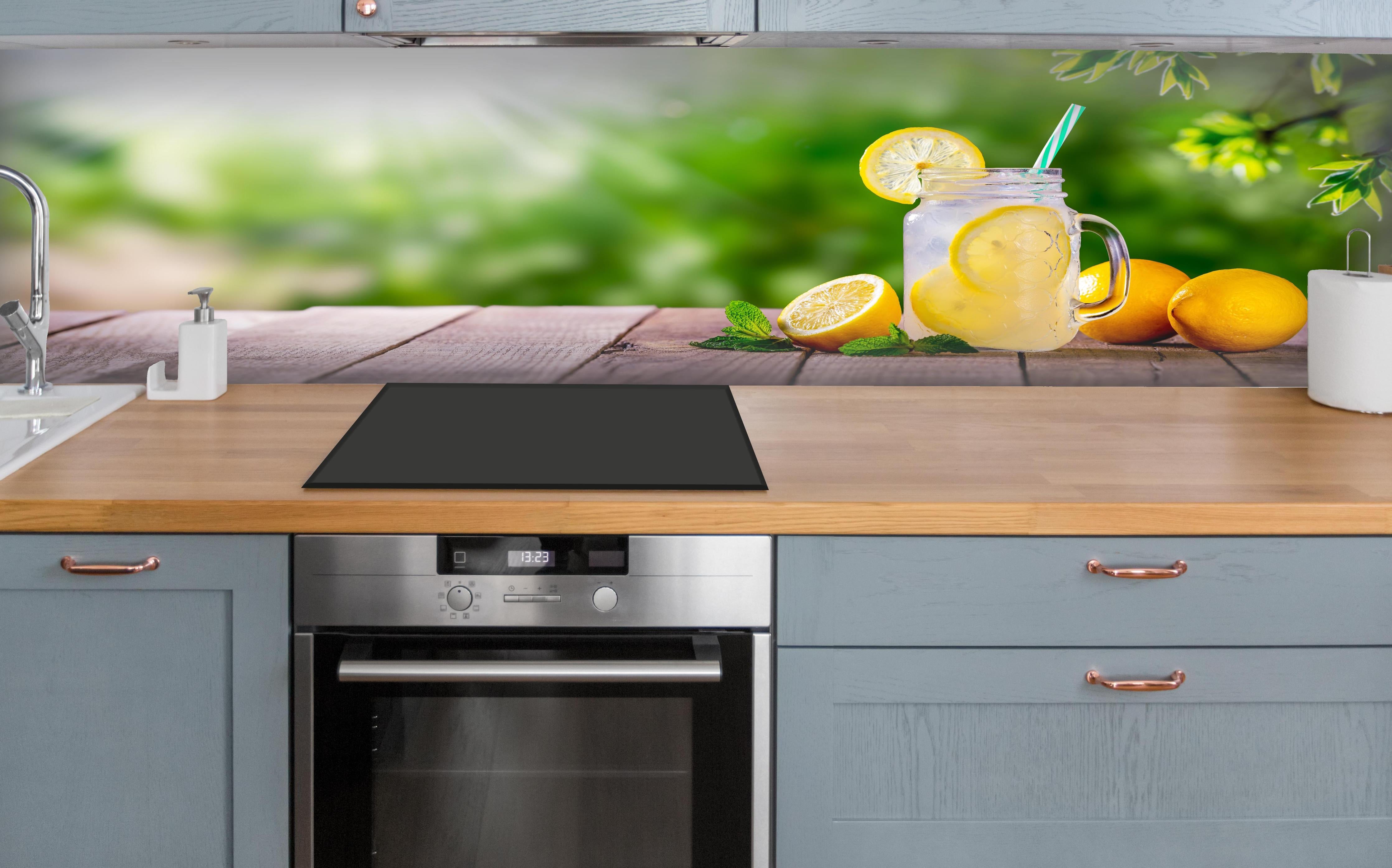 Küche - Zitronen-Limonade auf Holztisch über polierter Holzarbeitsplatte mit Cerankochfeld