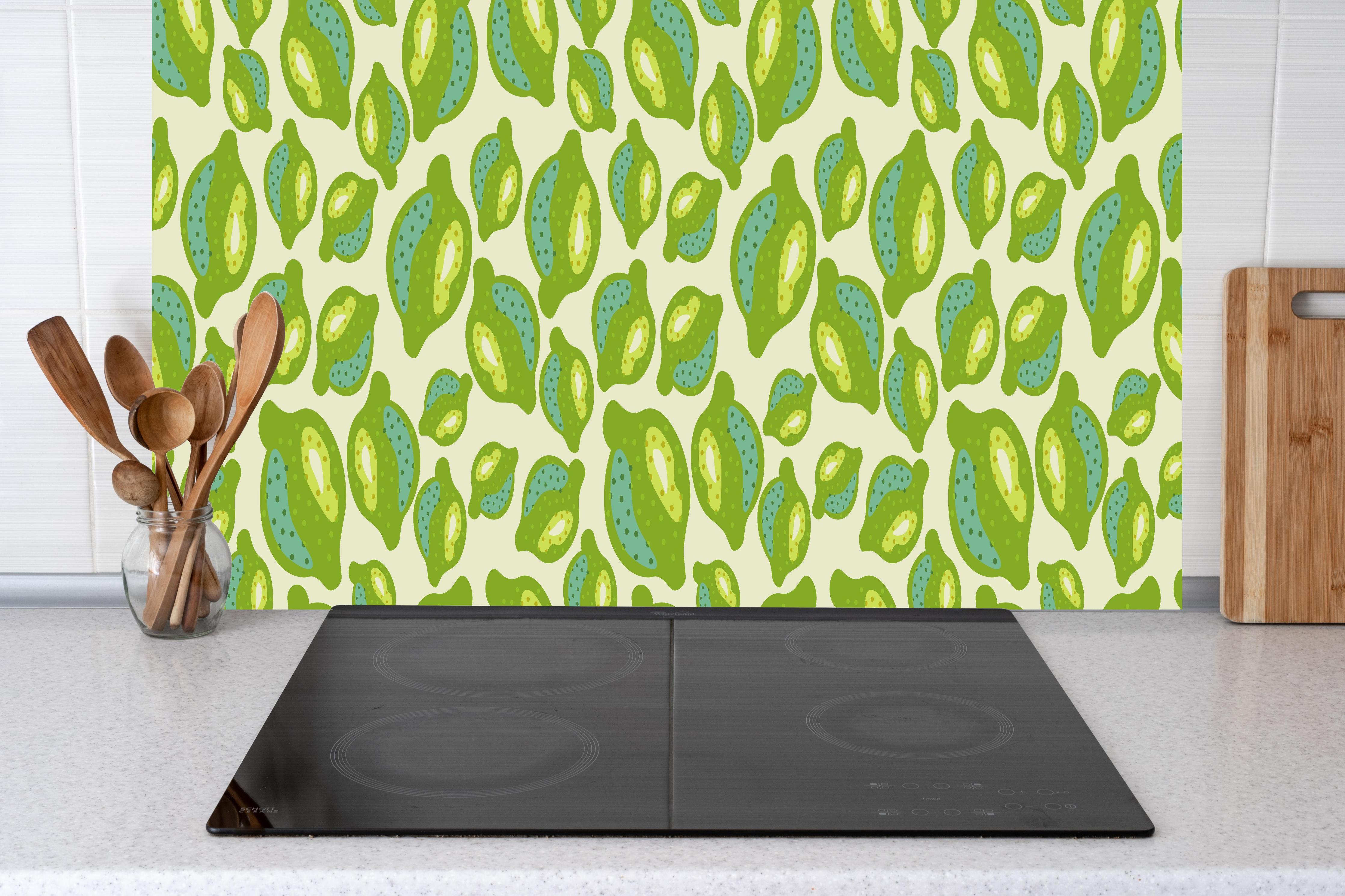 Küche - Zitrus-Limetten-Muster Grün hinter Cerankochfeld und Holz-Kochutensilien