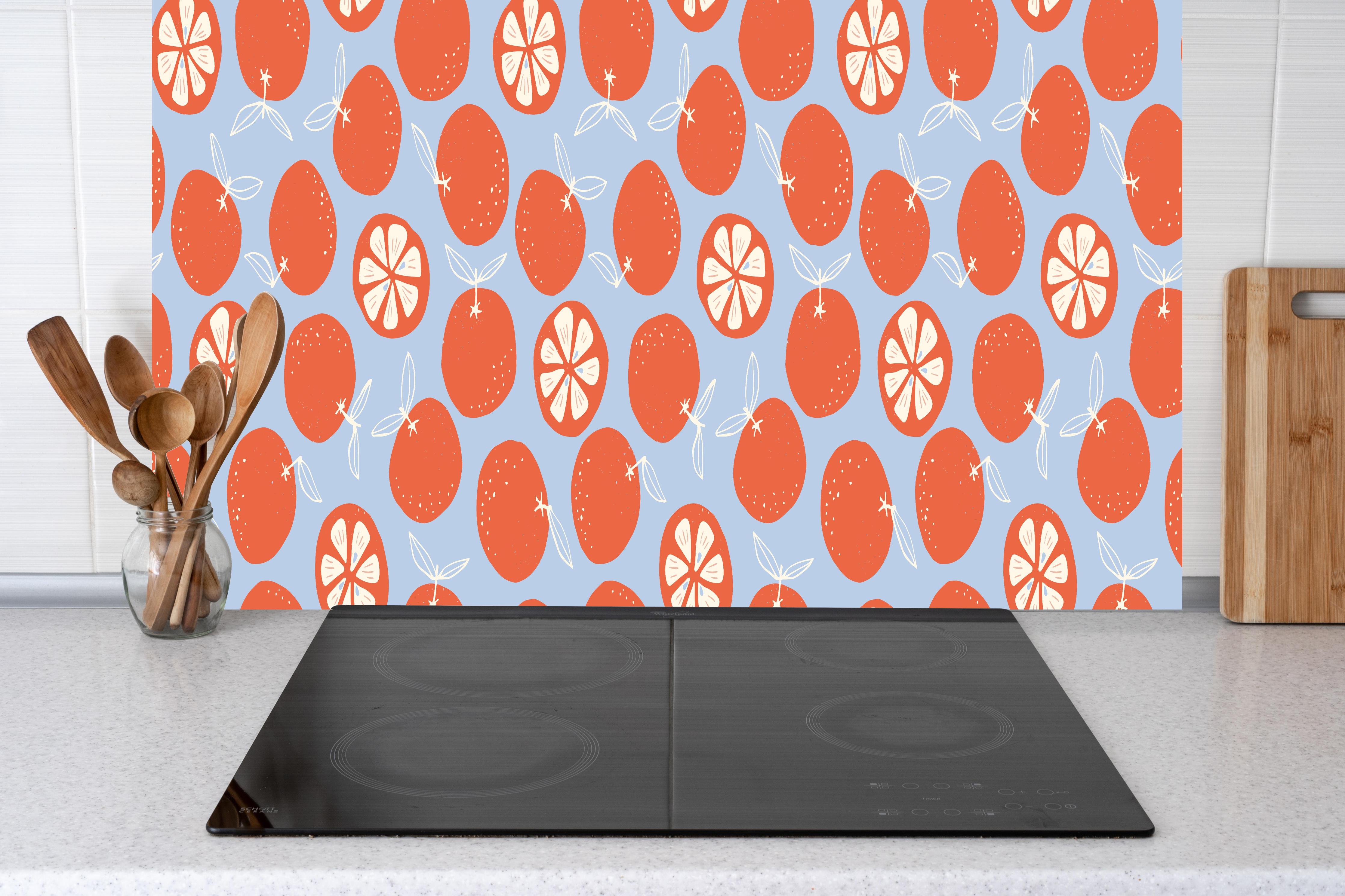 Küche - Zitrus-Orangenmuster Coral Glow hinter Cerankochfeld und Holz-Kochutensilien