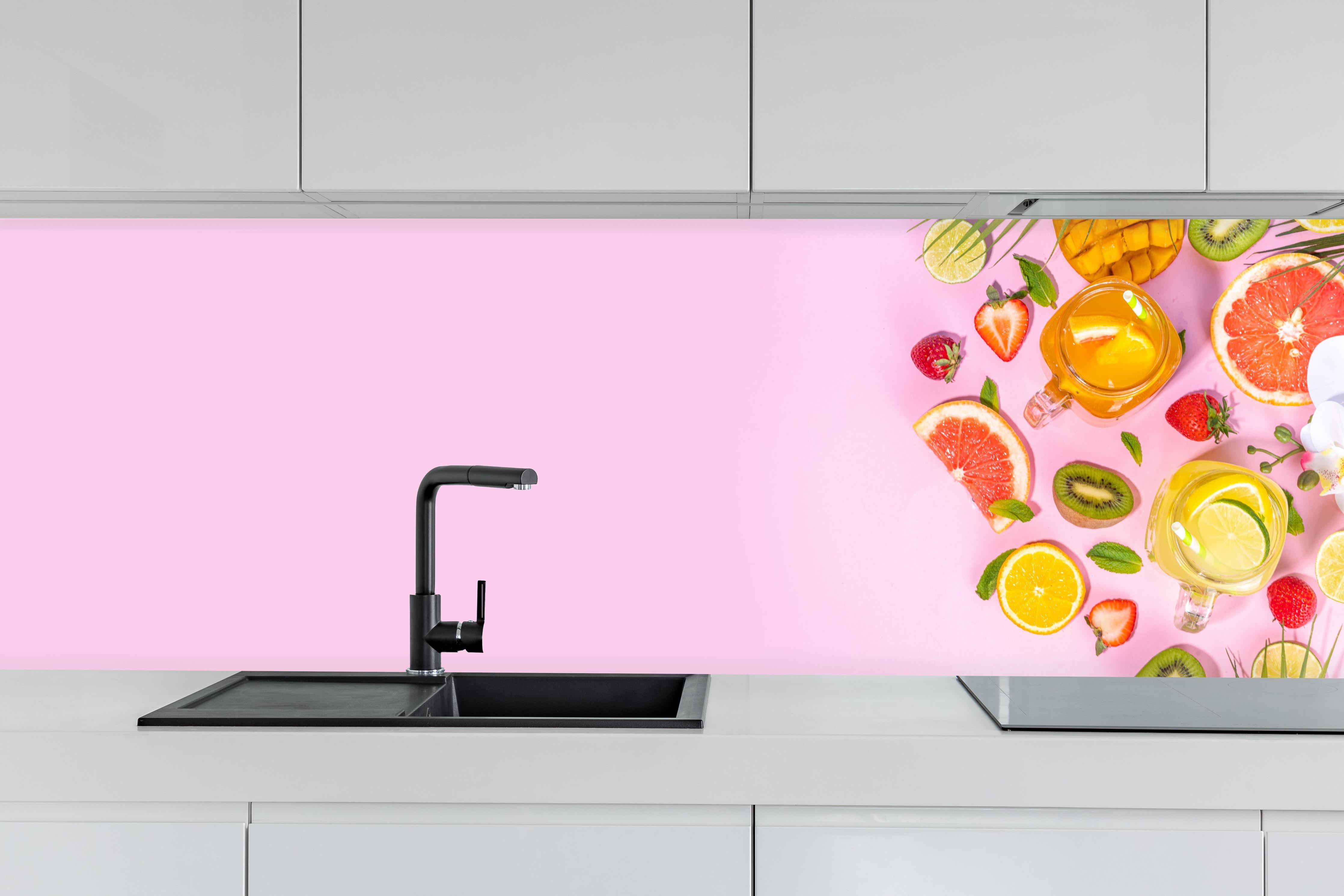 Küche - Zitrusfrüchte auf rosa Hintergrund hinter weißen Hochglanz-Küchenregalen und schwarzem Wasserhahn