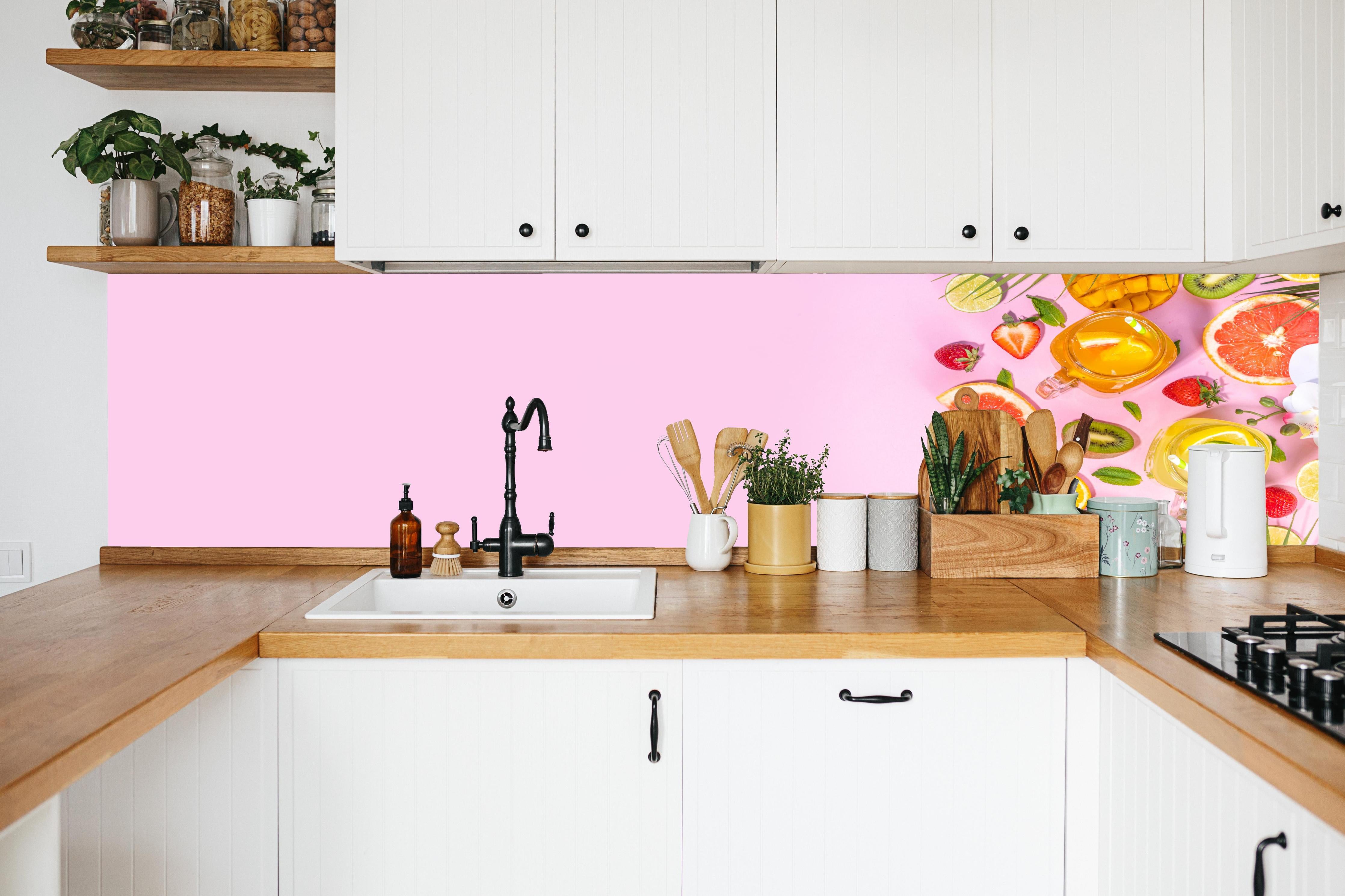 Küche - Zitrusfrüchte auf rosa Hintergrund in weißer Küche hinter Gewürzen und Kochlöffeln aus Holz