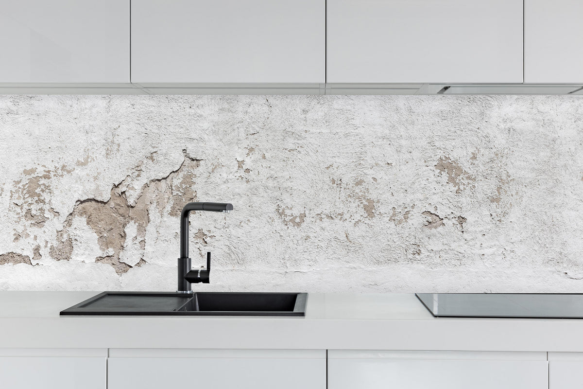 Küche - Alte Mauer mit abblätterndem Putz hinter weißen Hochglanz-Küchenregalen und schwarzem Wasserhahn