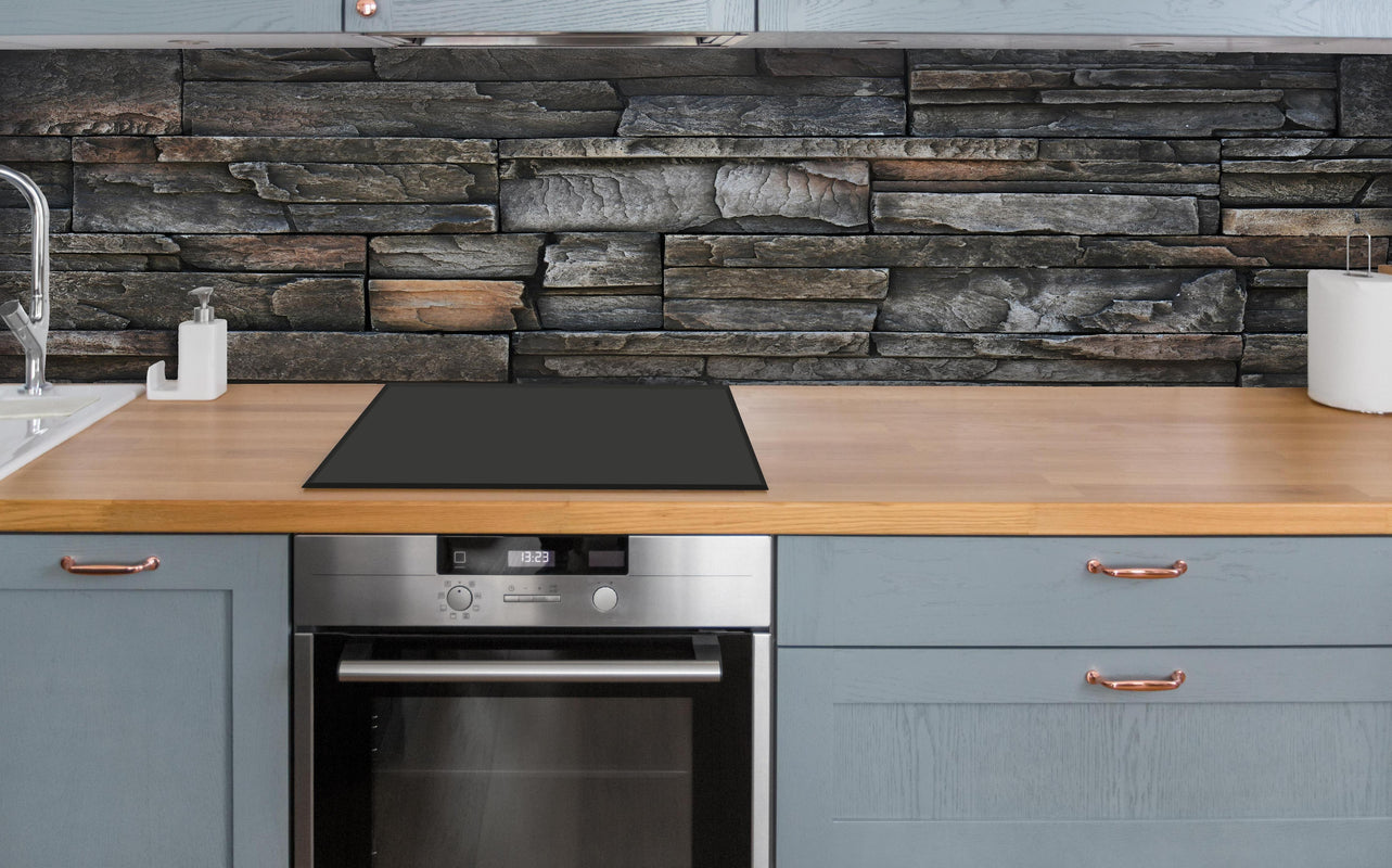 Küche - Alte dunkle Steinwand Textur über polierter Holzarbeitsplatte mit Cerankochfeld
