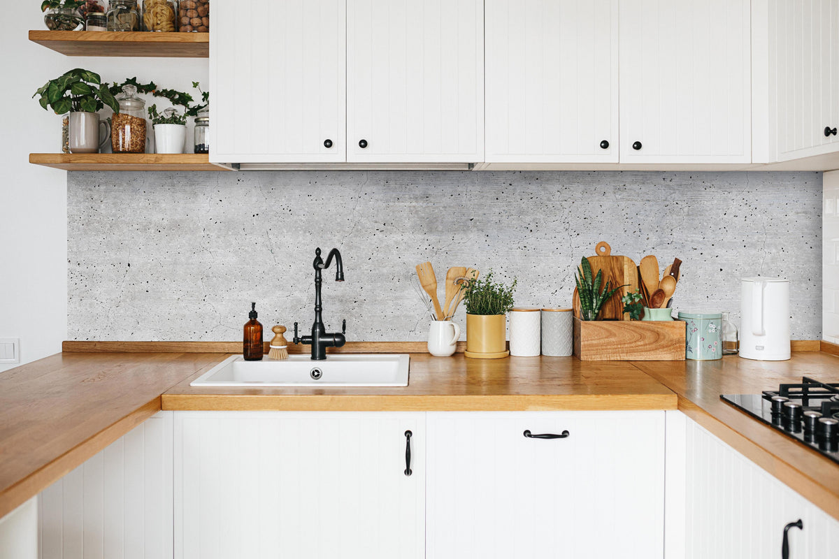 Küche - Alte gräuliche Betonmauer in weißer Küche hinter Gewürzen und Kochlöffeln aus Holz