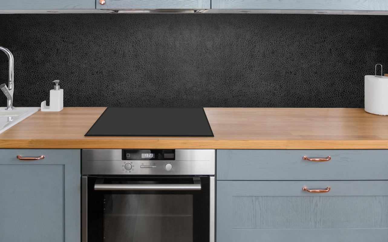Küche - Alte schwarze Leder Textur über polierter Holzarbeitsplatte mit Cerankochfeld