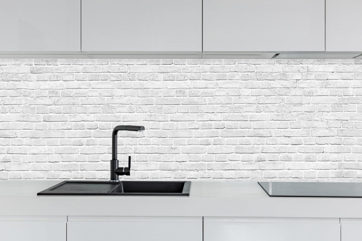Küche - Alte weiße Backsteinmauer hinter weißen Hochglanz-Küchenregalen und schwarzem Wasserhahn